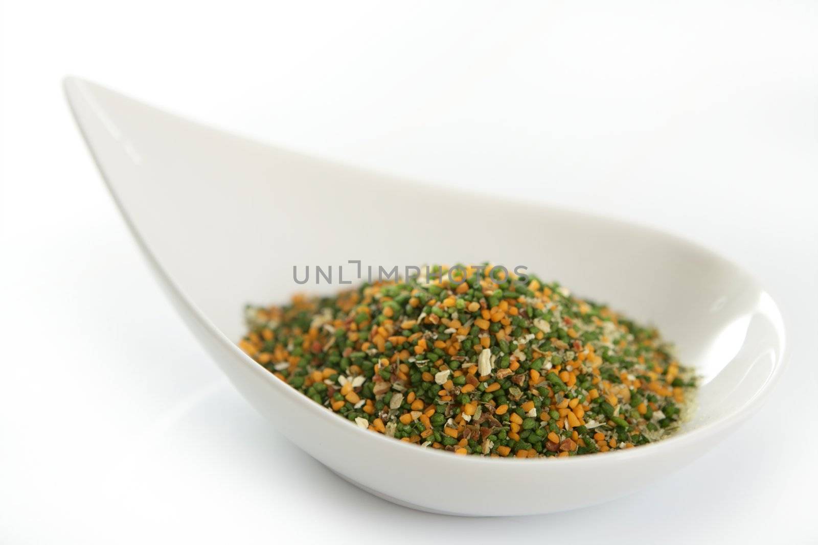 Multicolor vegetables semolina textures in white dish, white background