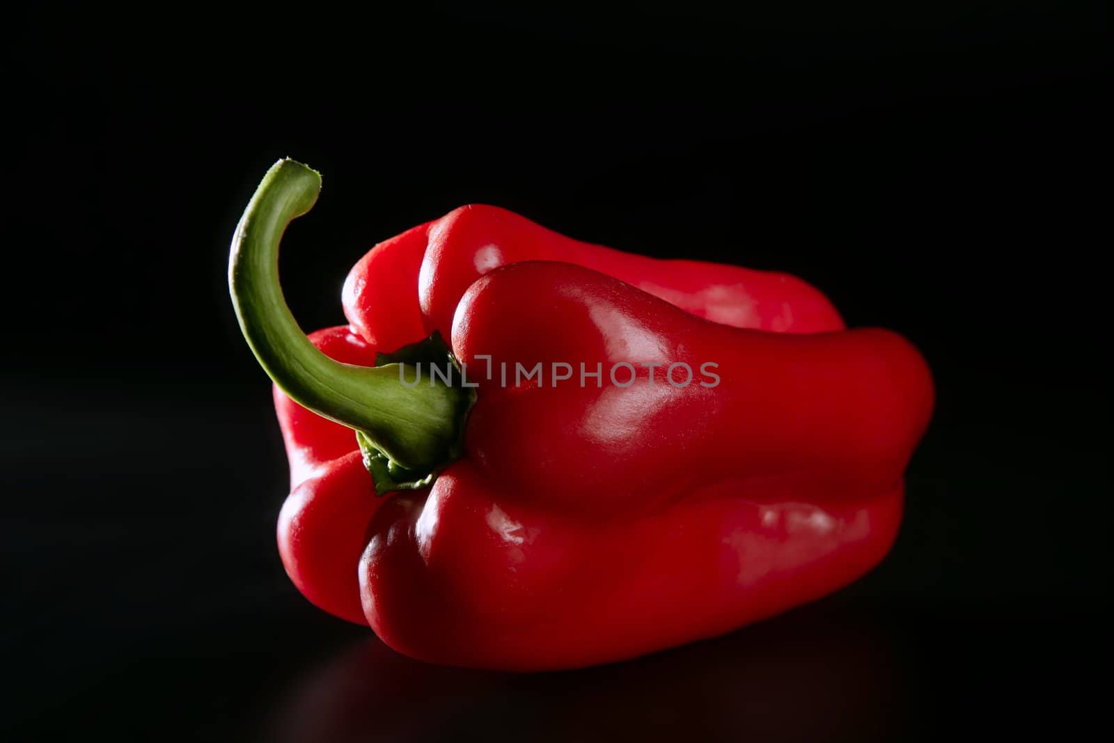 Red macro pepper close up over black background