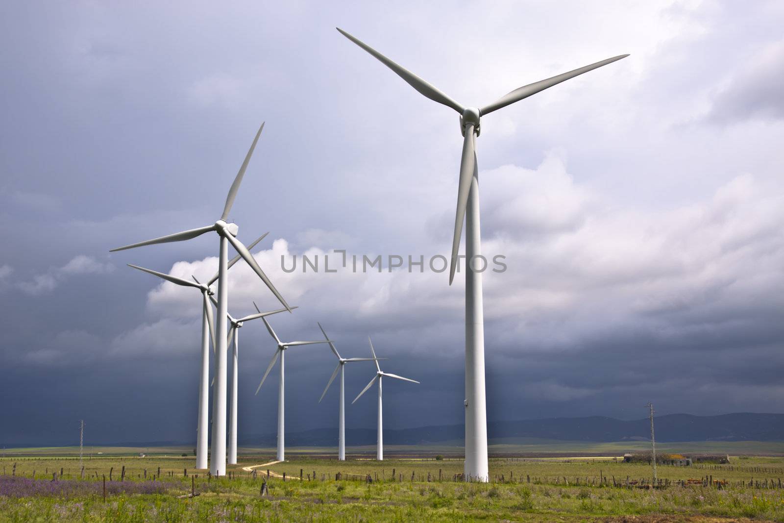 Wind turbines generating electricity in a stormy weather.