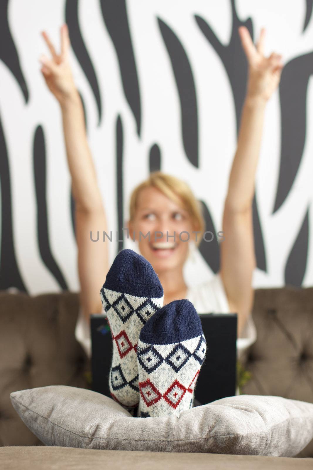 Exited beautiful young lady using web on the laptop