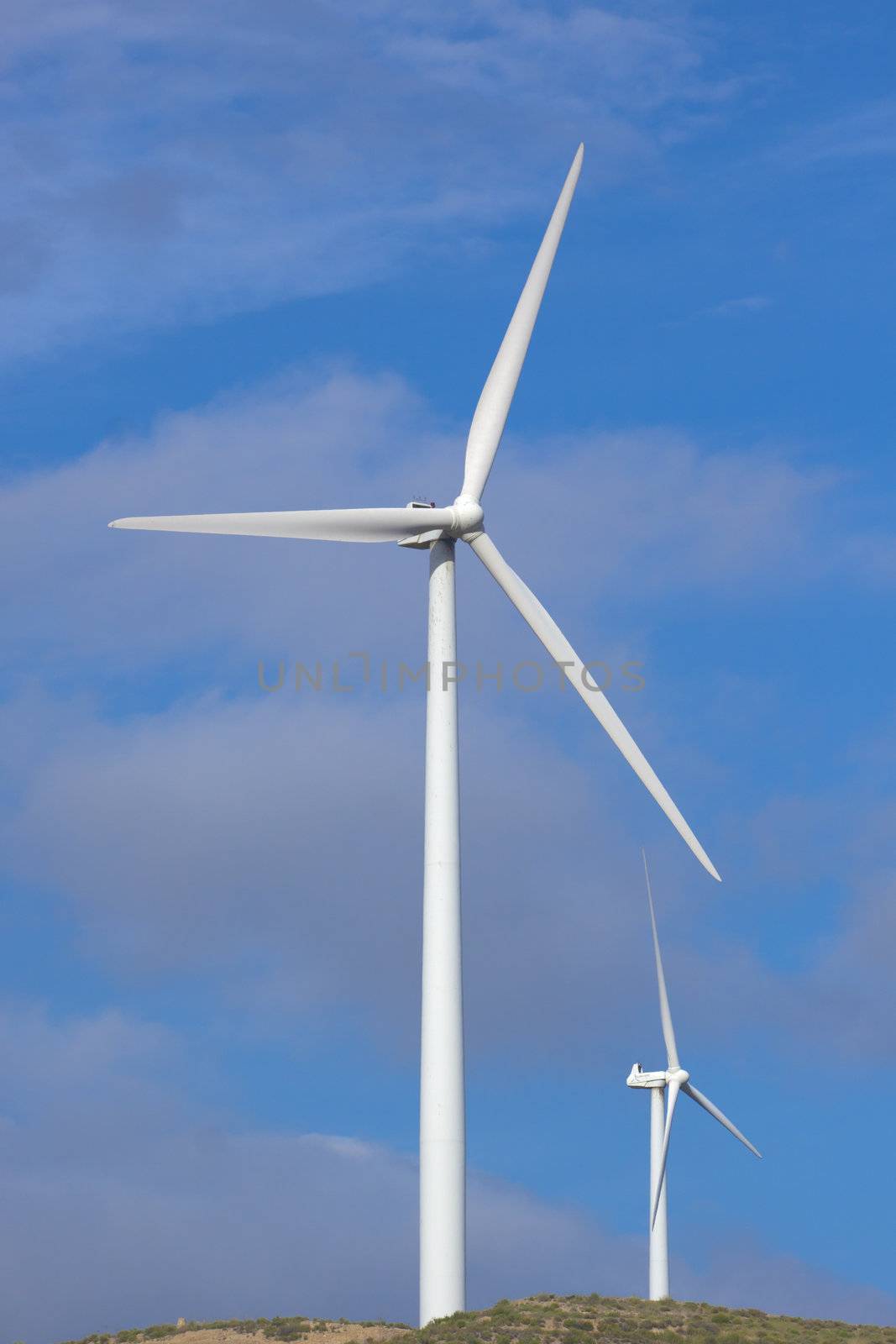 Wind turbine generating electricity with a nice white cloud on the sky