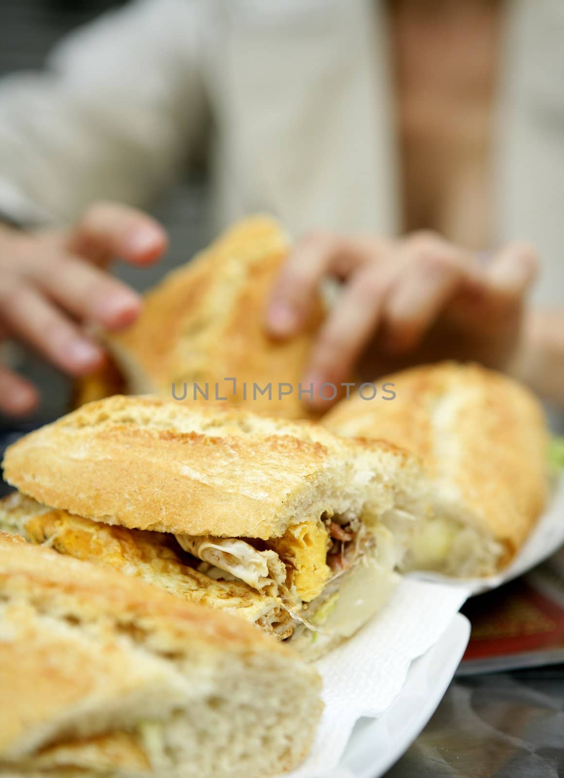 Delicious breakfast, omelet sandwich. Woman hands holding the food