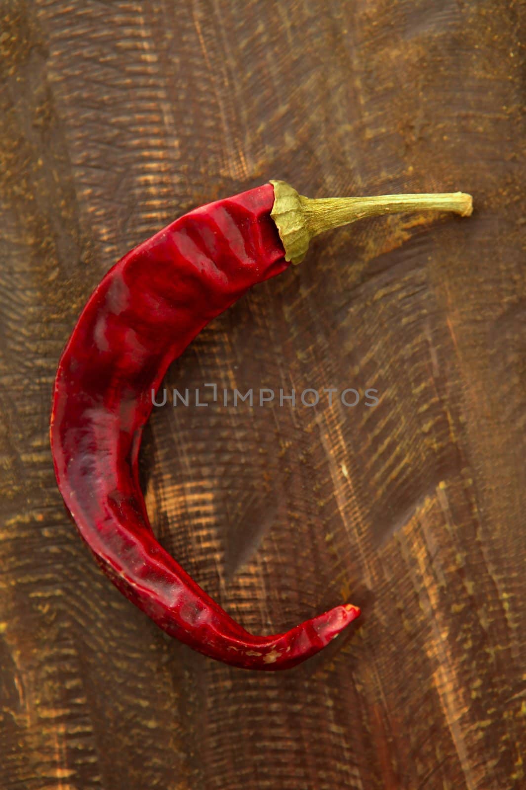 Red dried hot chili pepper over a dark wood background