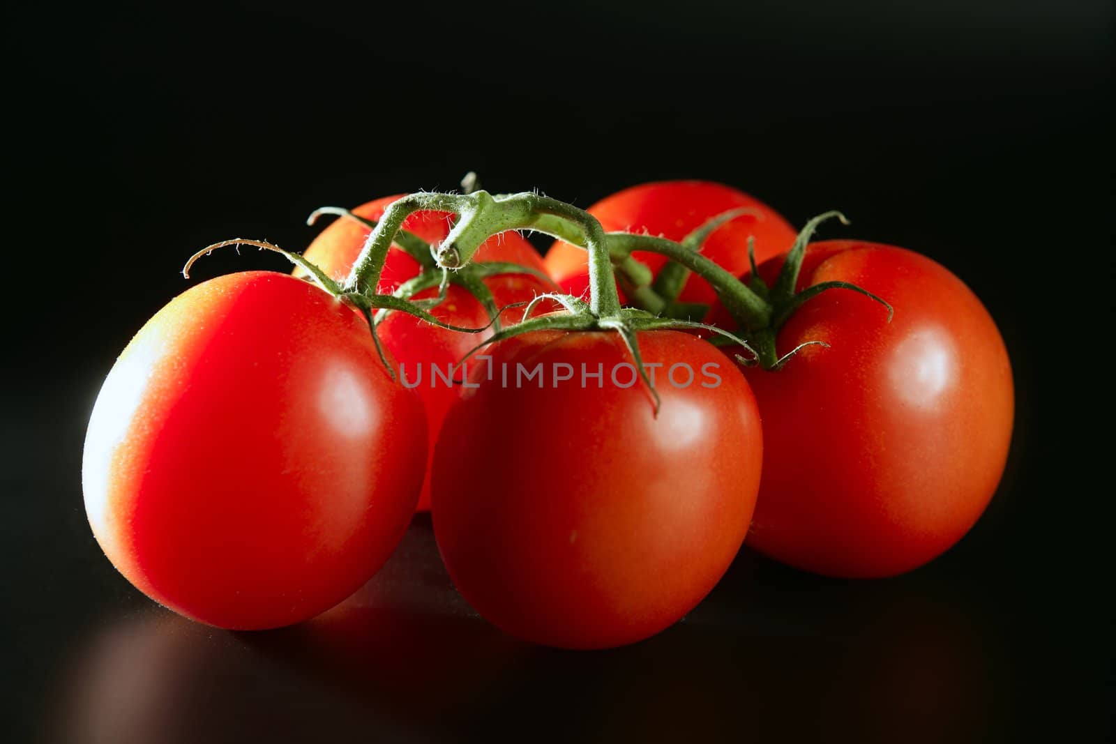 Cluster red tomato over dark black background