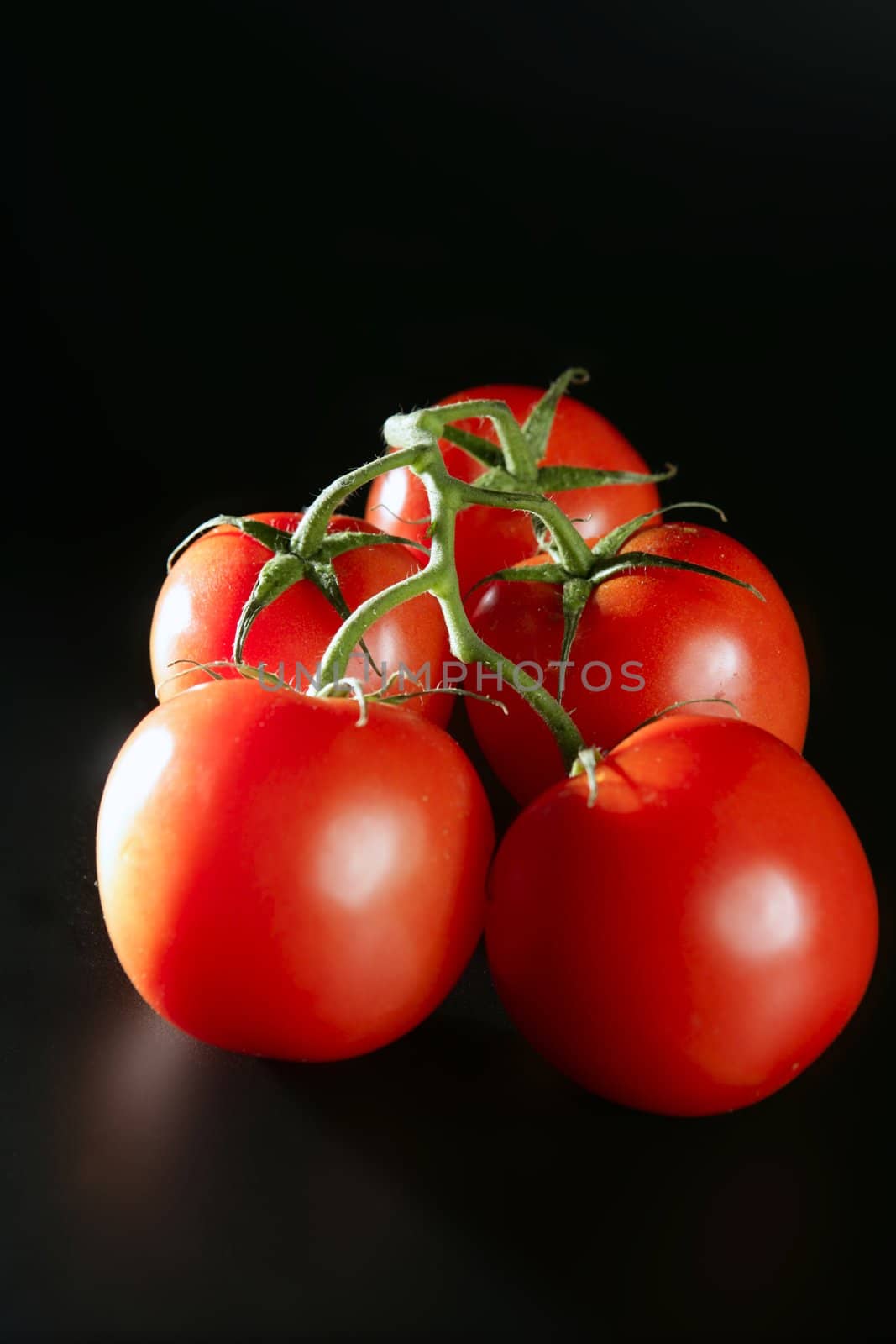 Cluster red tomato over dark black background