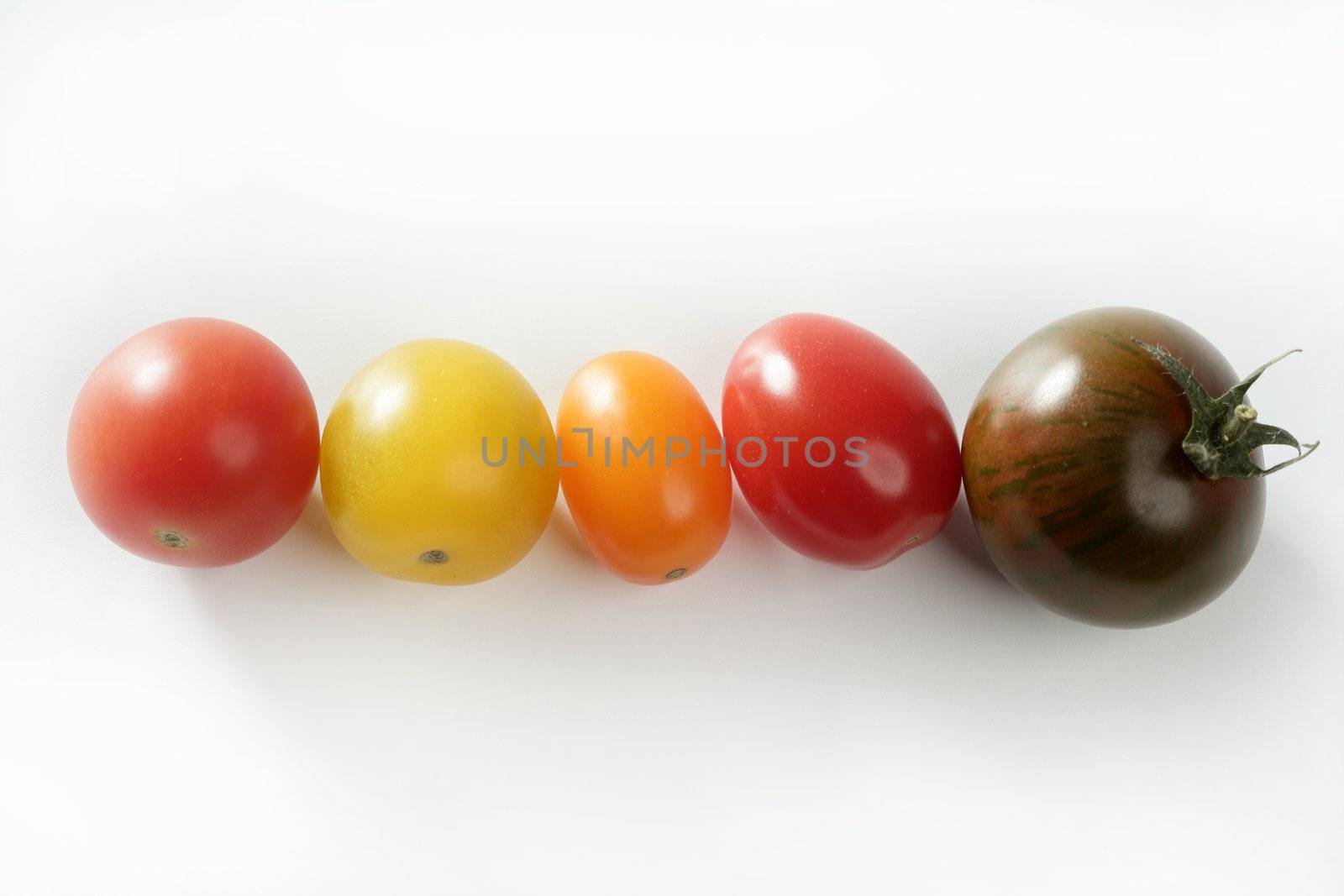 Little cherry varied multi color tomatoes, at studio, white background