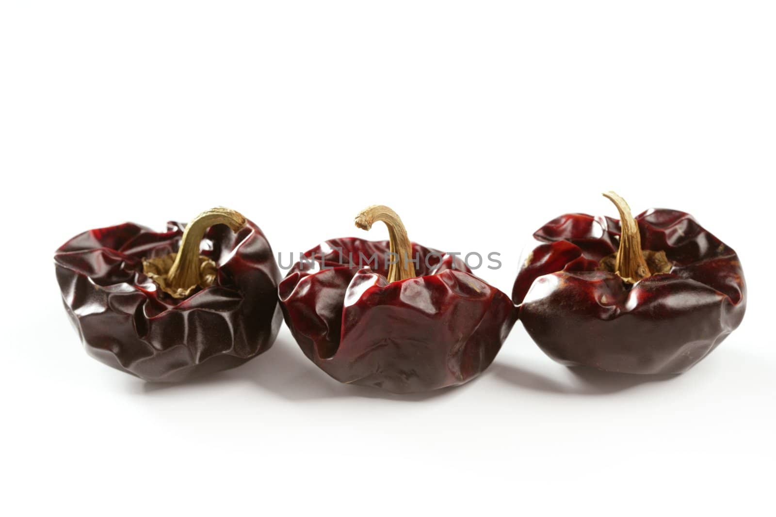 Three round Mediterranean dried dark red peppers by lunamarina