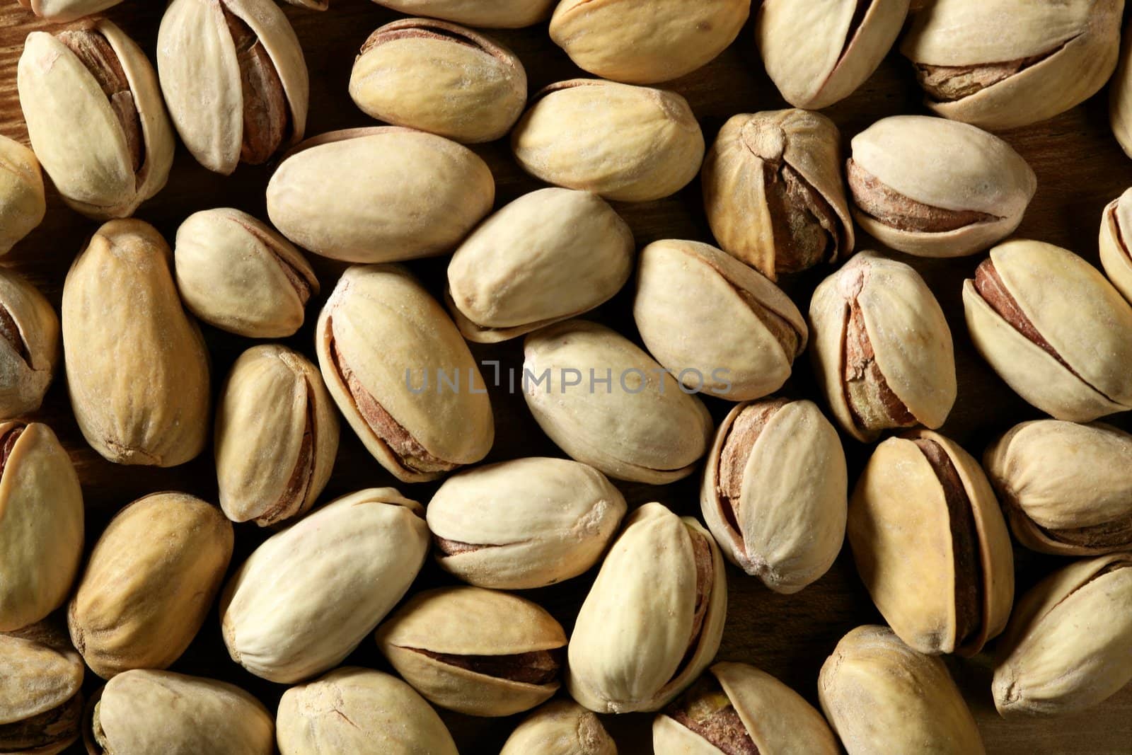 Pistachio shelled macro crop texture in brown color background