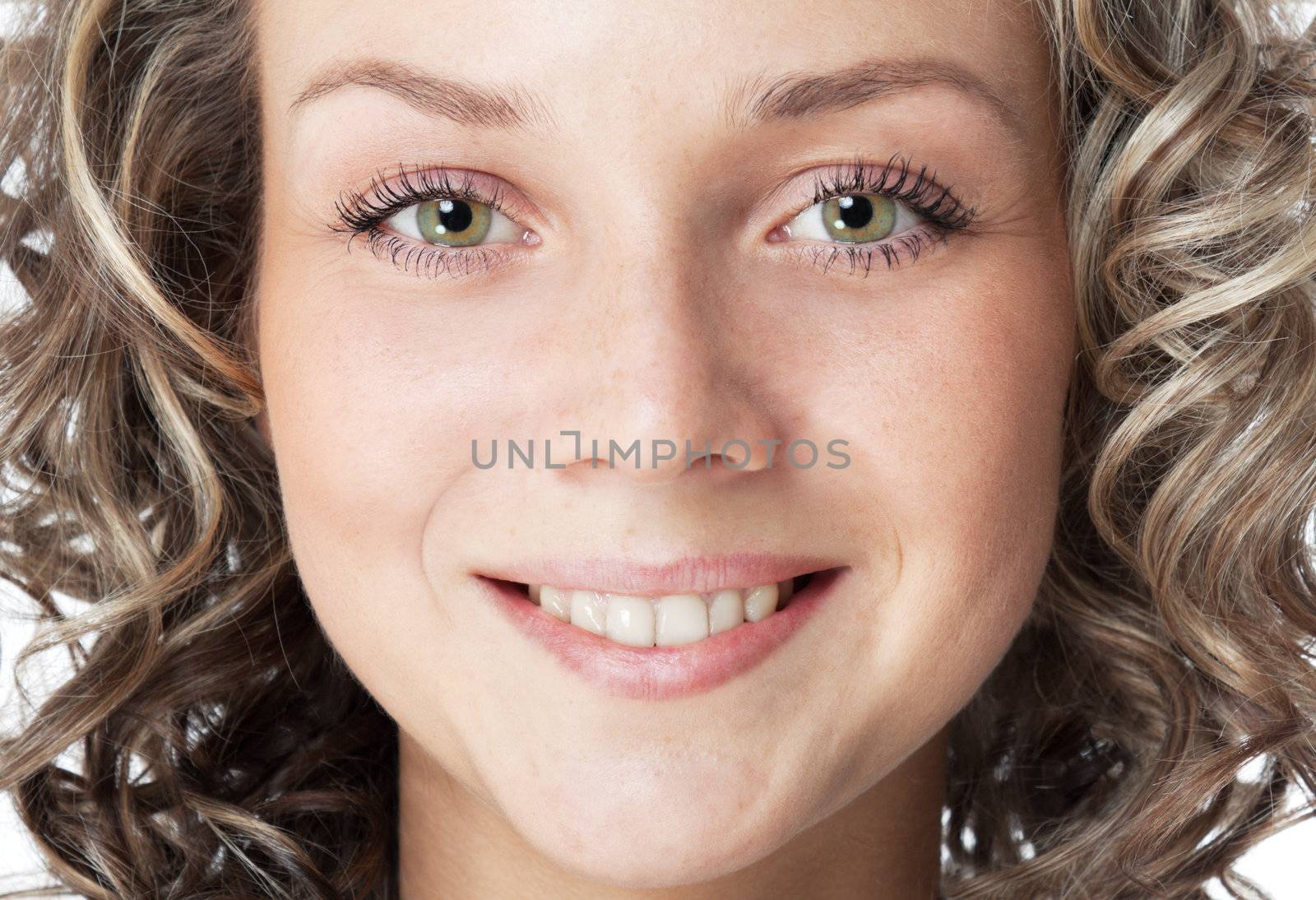 Closeup portrait of a smiling young woman. Green eyes and toothy smile