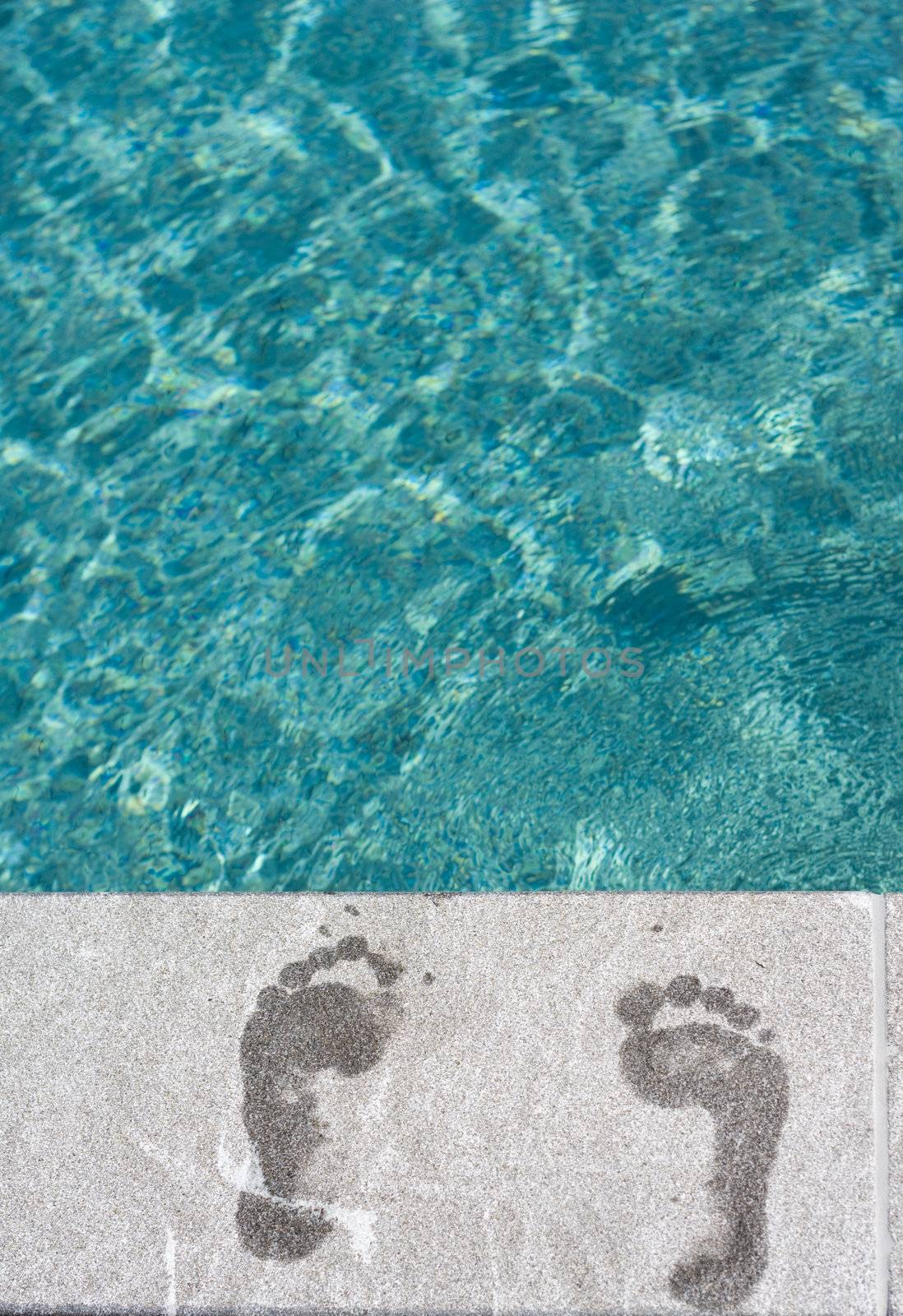 Footprints with turqoise blue swimming pool at vacation resort