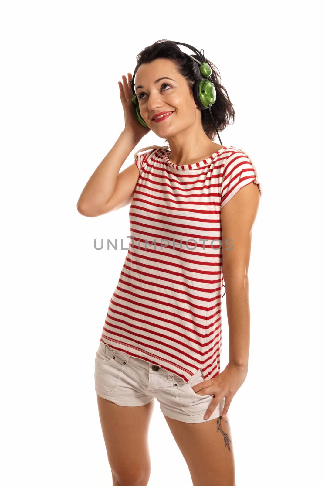 Young woman listening music with headphones standing on white background