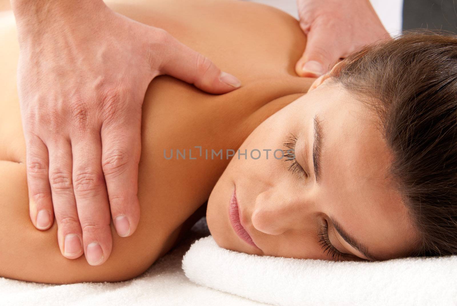 Woman receiving massage relax treatment close-up portrait from male hands by dgmata
