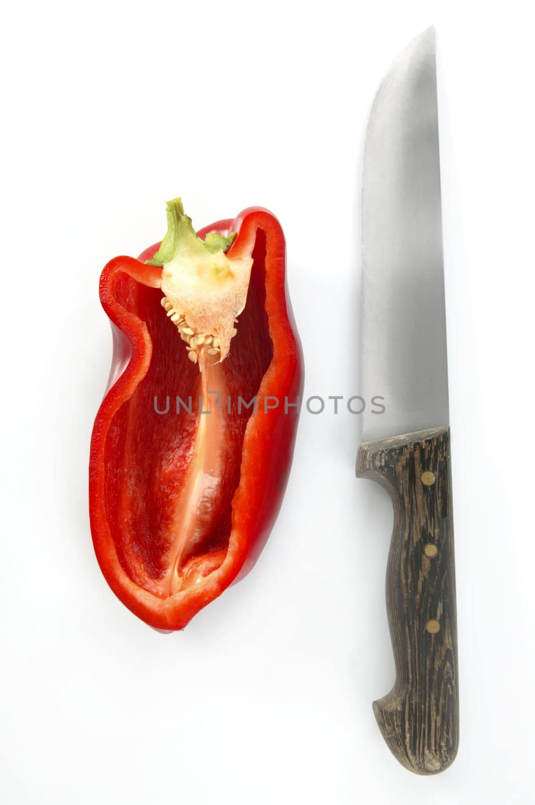 Half red pepper and knife isolated over white studio background