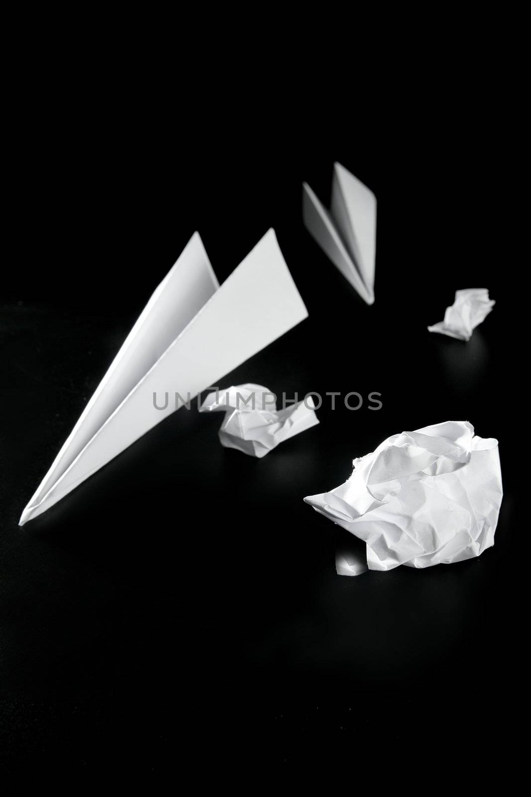 Trash paper and air plane, bored in the office metaphor, over black