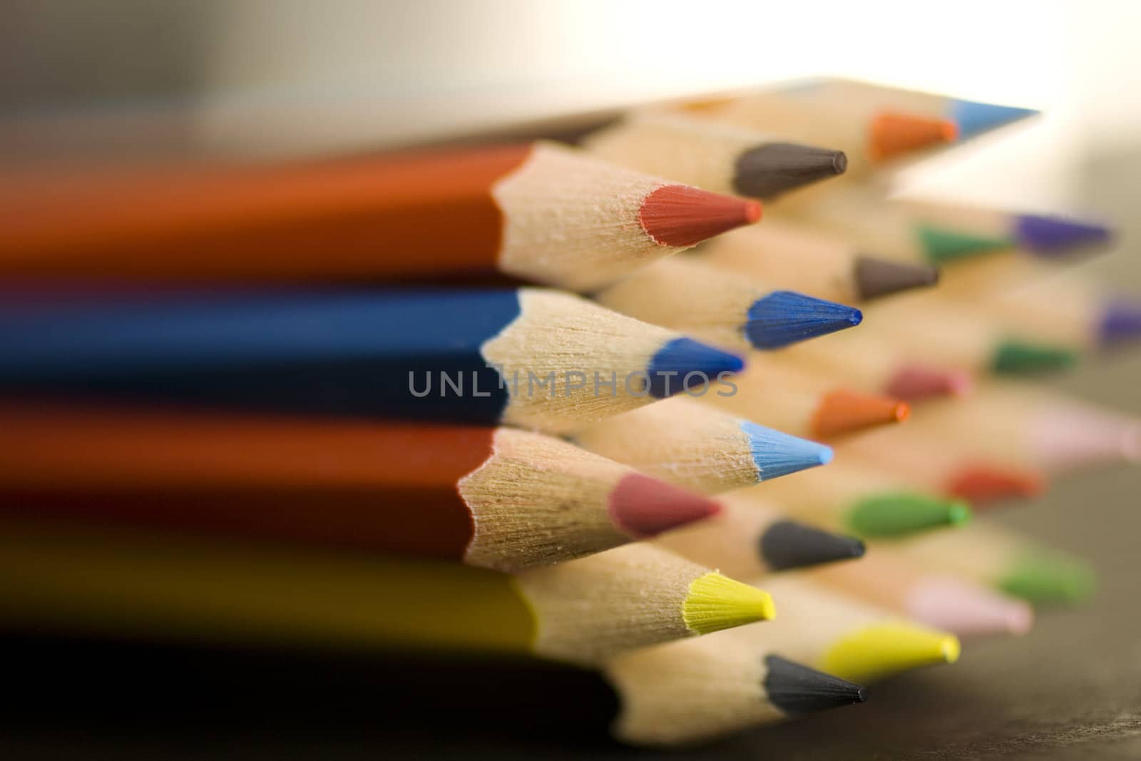 Close up of group of multi-colored coloring pencils isolated on blsck background.