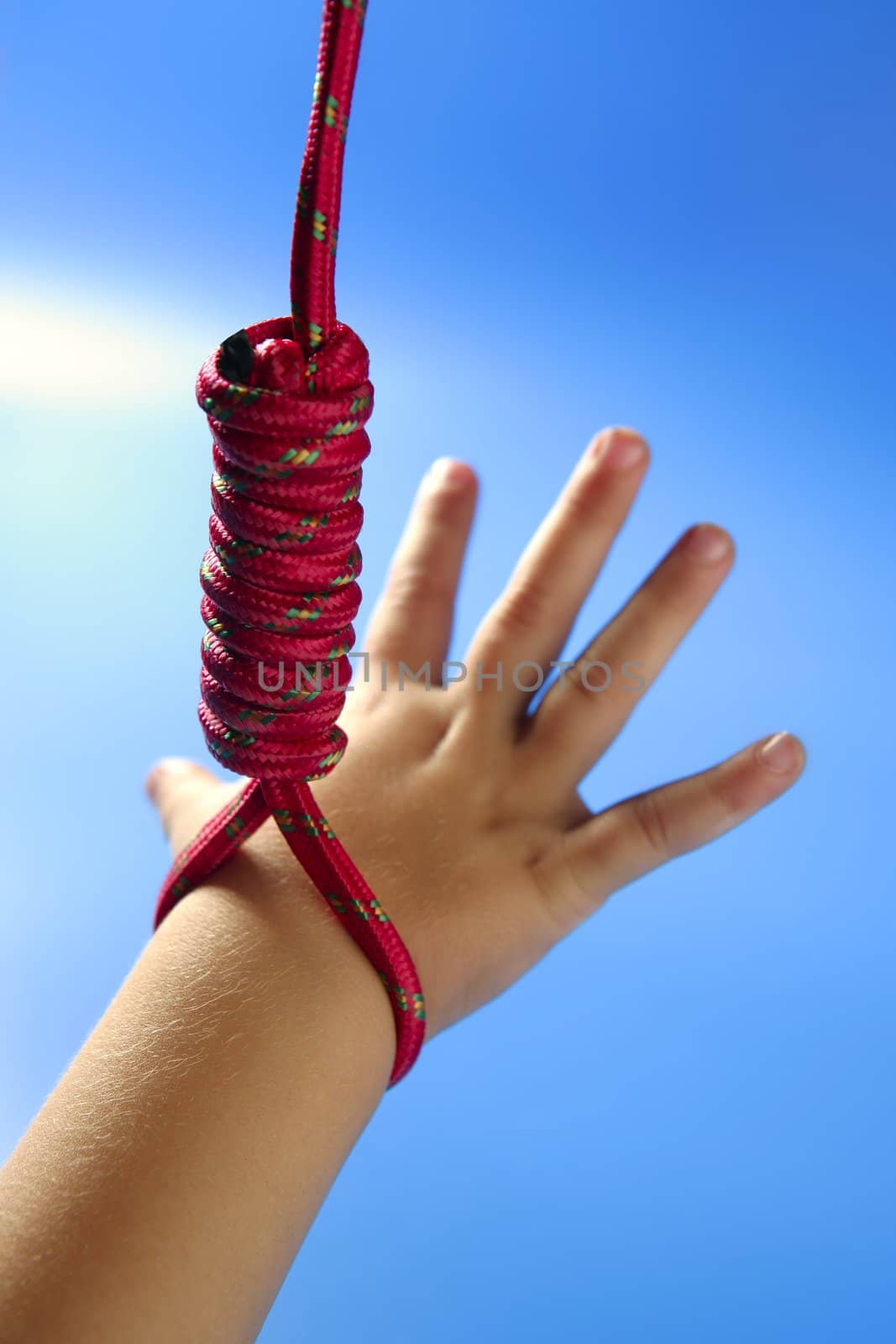 Children hand hanged on red thread, hangman knot, education metaphor