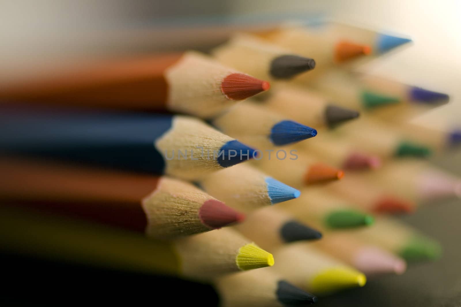 Close up of group of multi-colored coloring pencils isolated on blsck background.