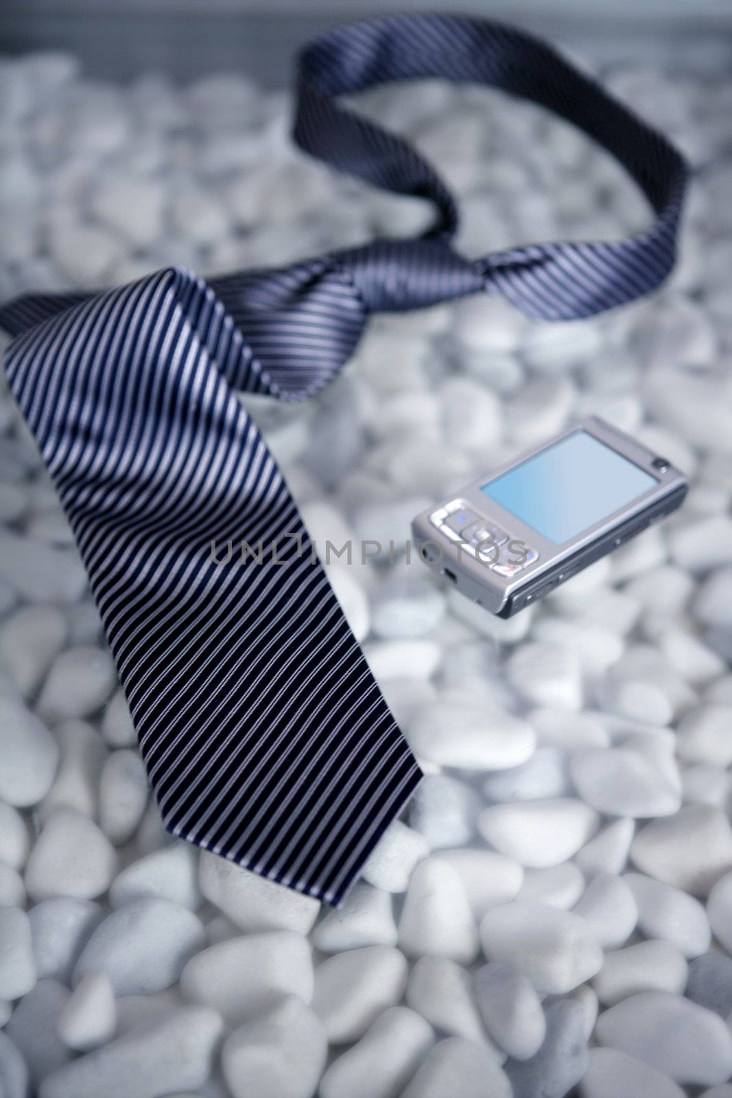 Businessman on a break, left his tie and phone on a modern white stones table