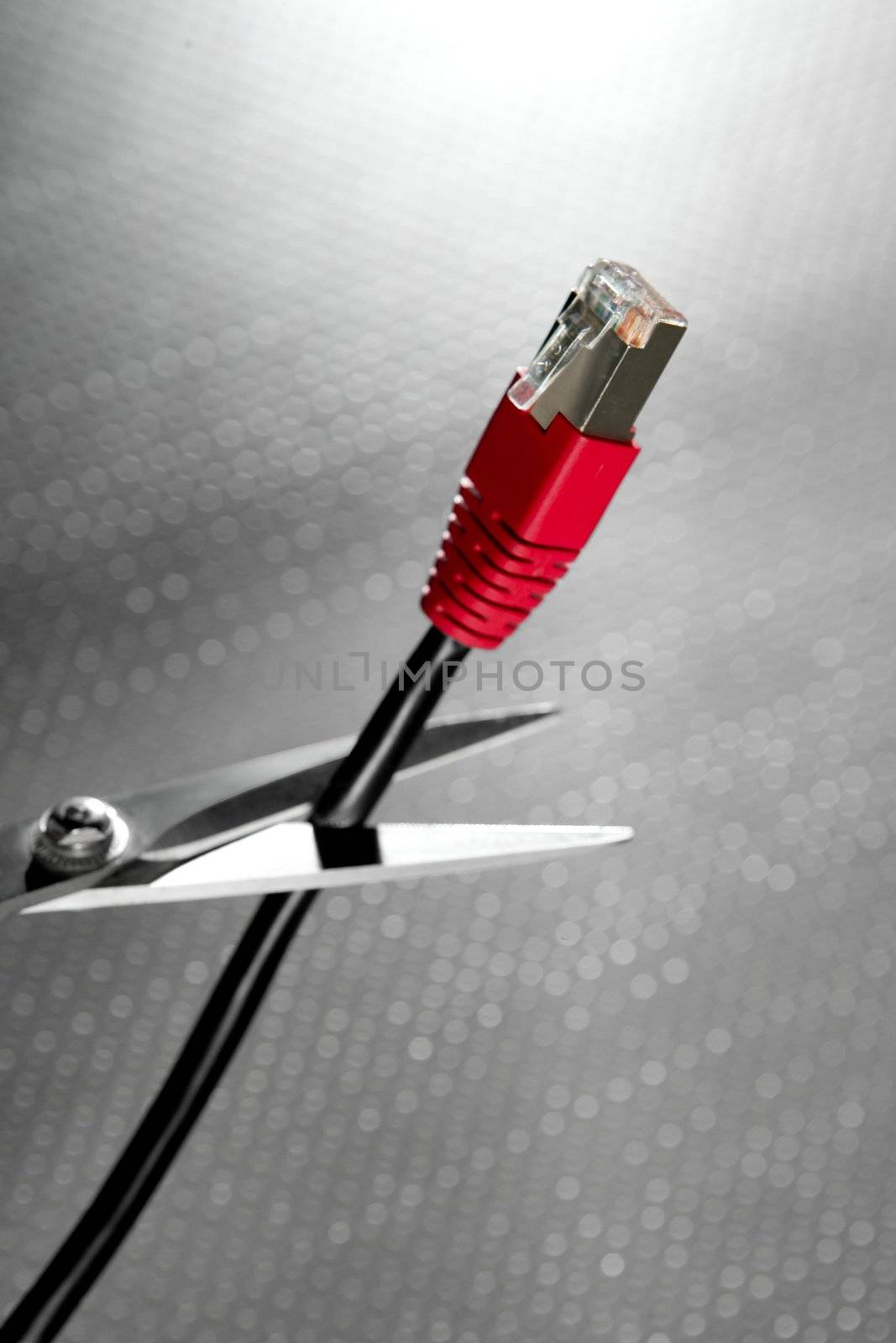 Cutting with scissors a network RJ45 red cable connection by lunamarina