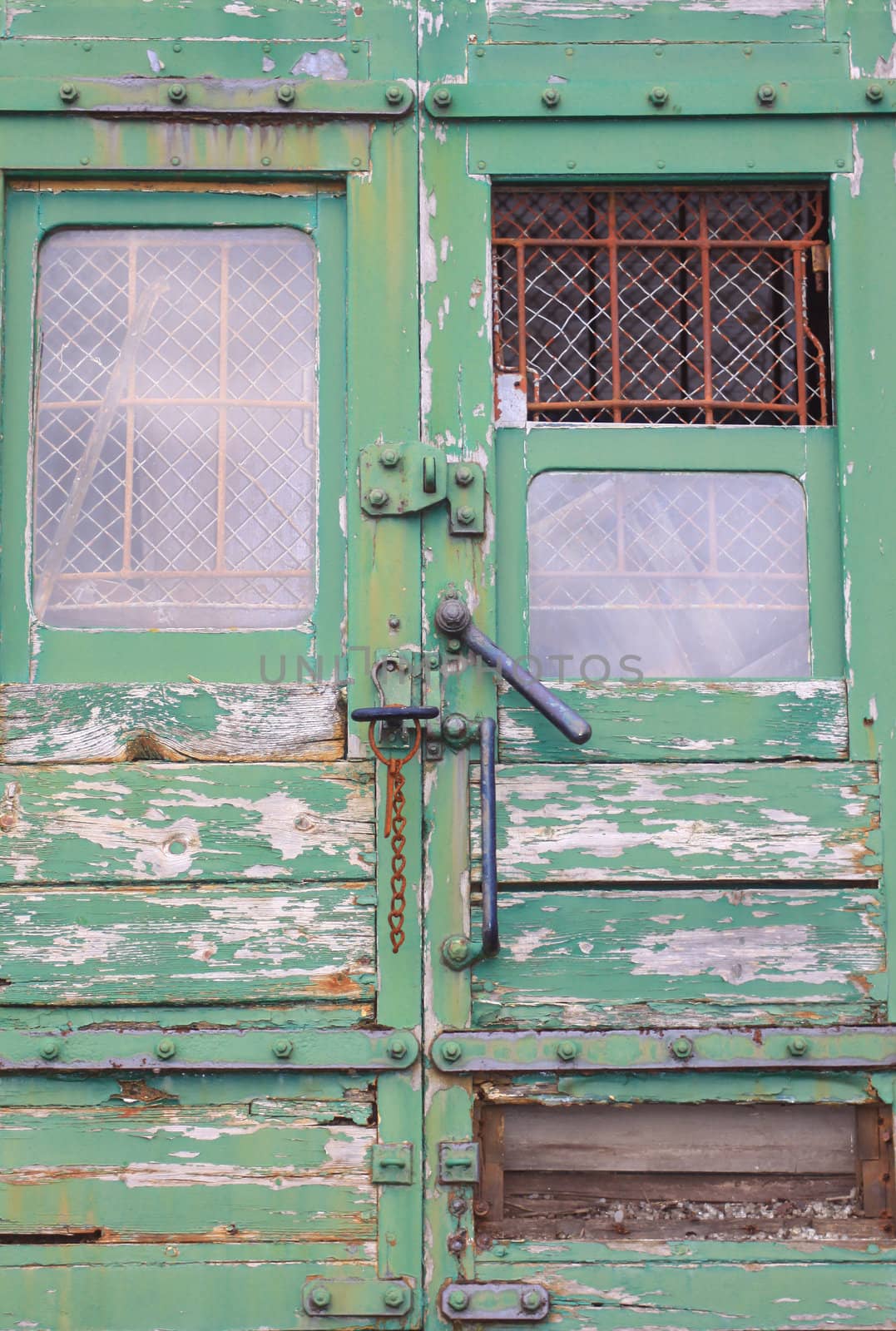 A derelict train with its door mechanism and barred and grilled windows. The entrannce to the mail section of the train.