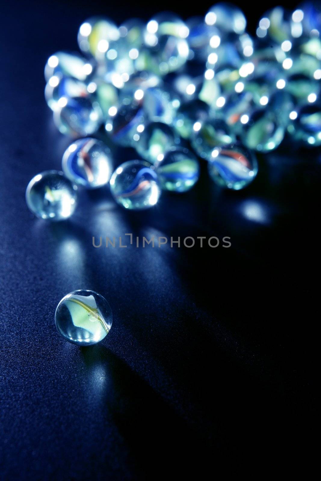 glass marbles with blue reflections over black background