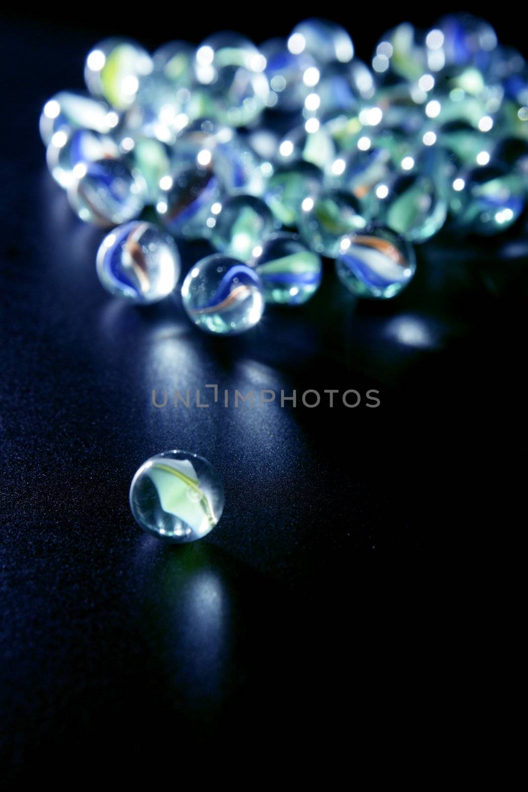 glass marbles with blue reflections over black background