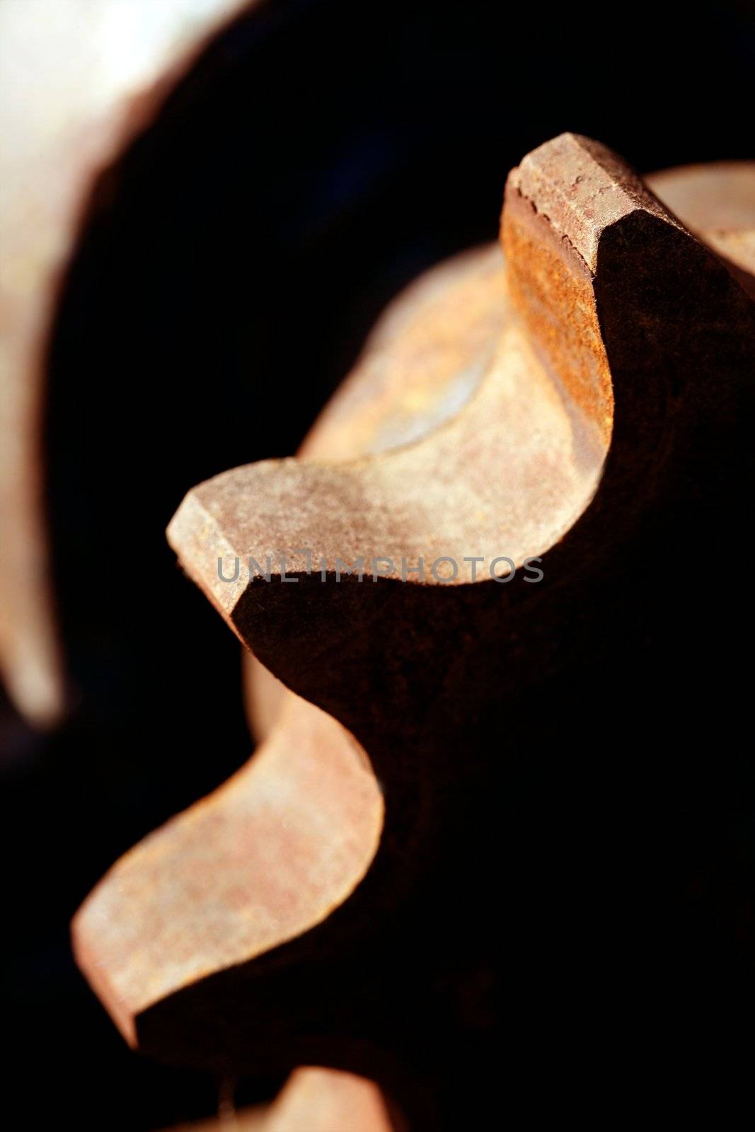 Rusty orange strong metal gear macro with sun strong shadows