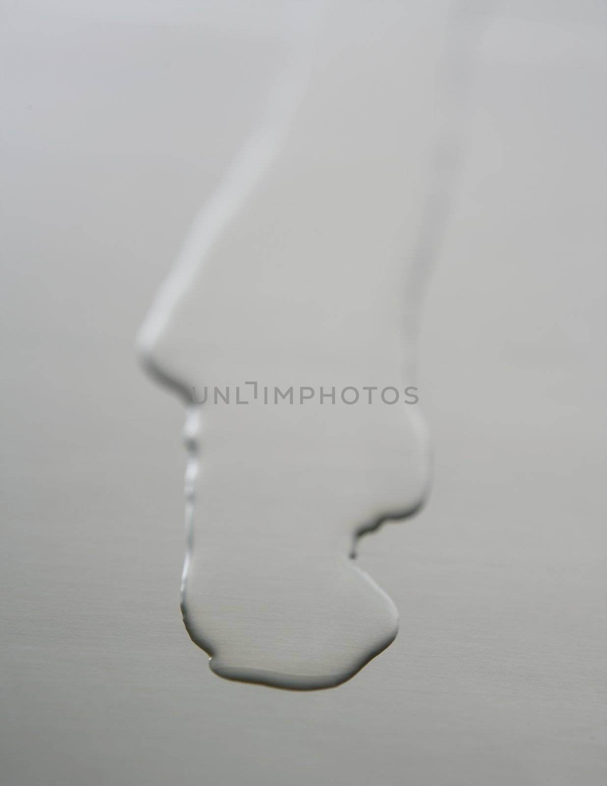 Liquid,transparent oil shape on a stainless steel metal surface