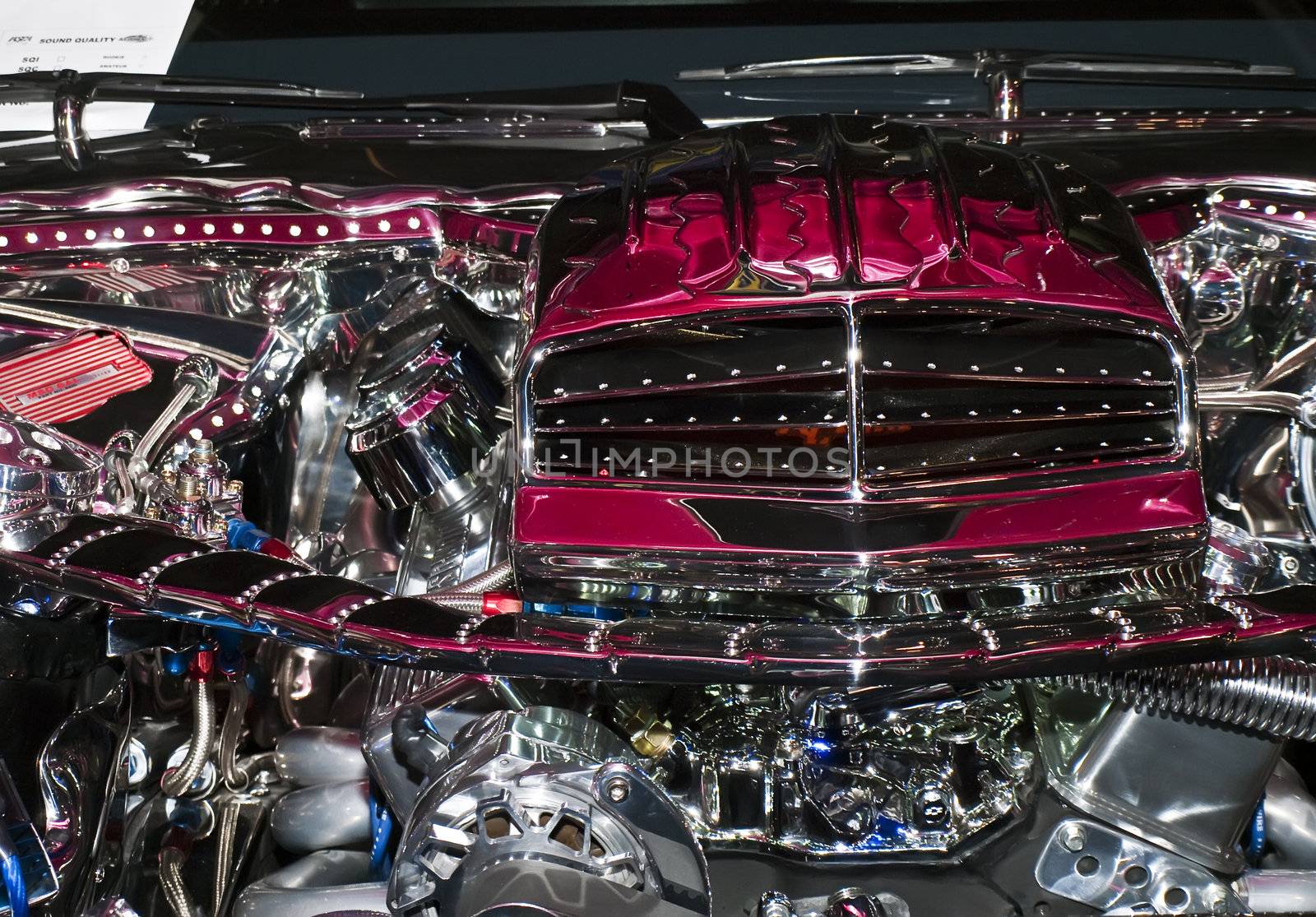 Detail from a modified car engine encased in shiny chrome and stainless steel