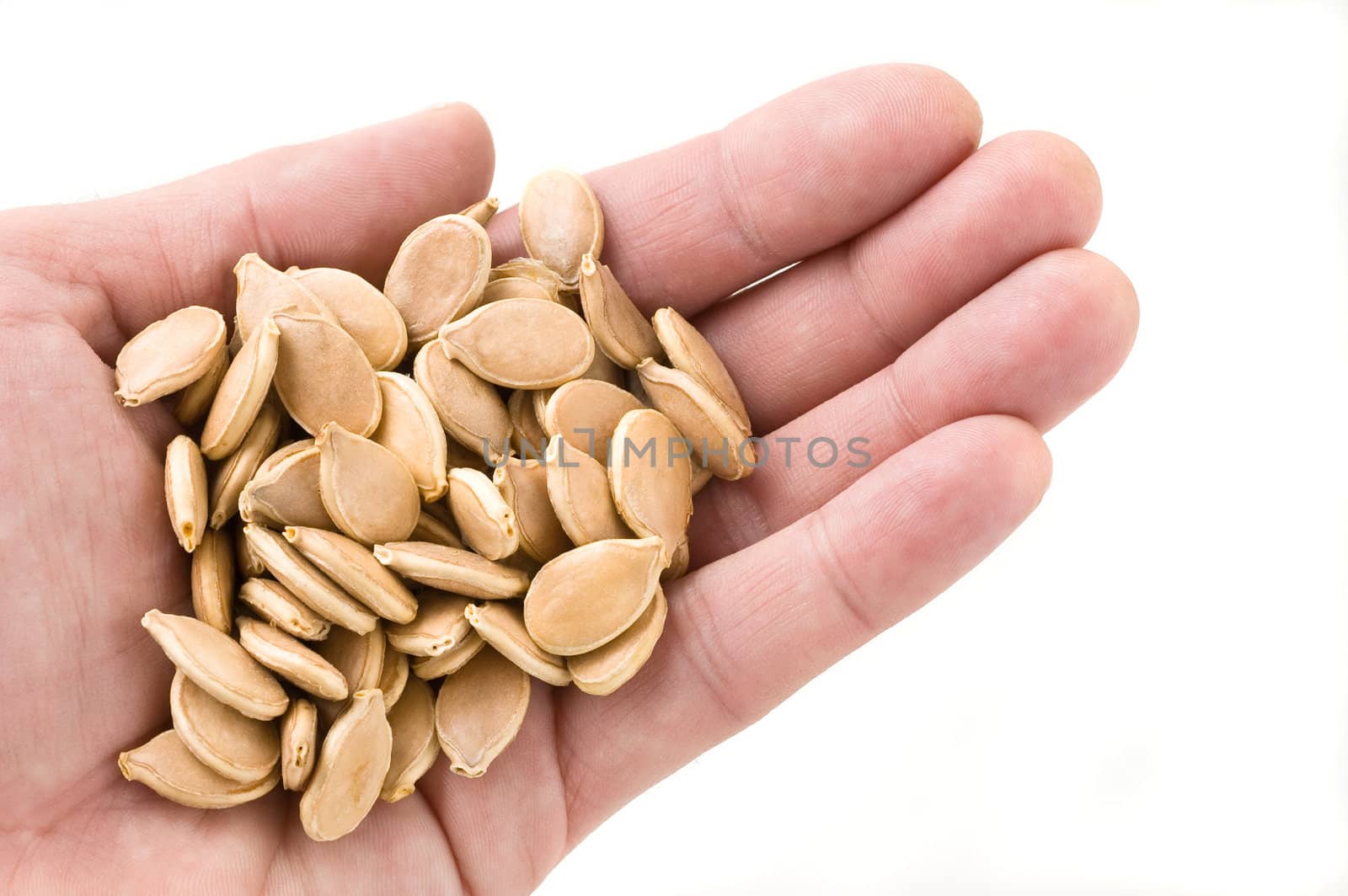 Handful of pumpkin seeds, white background, close up.