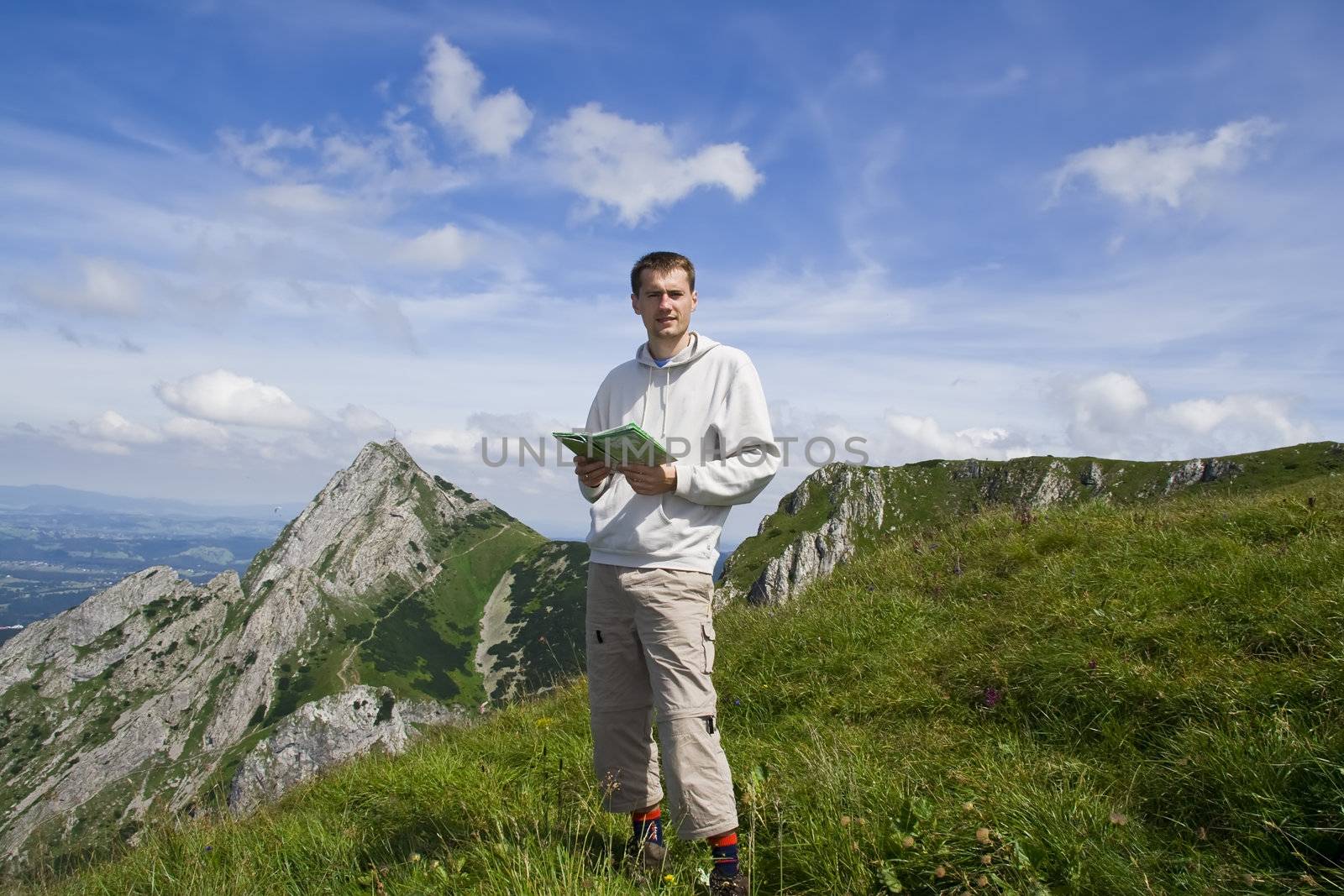 Mountain tourist with map over blue sky and mountains