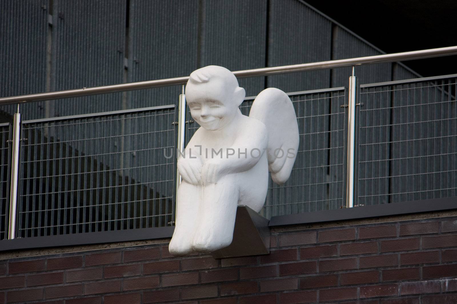 The white angel sits on the brink of a building roof