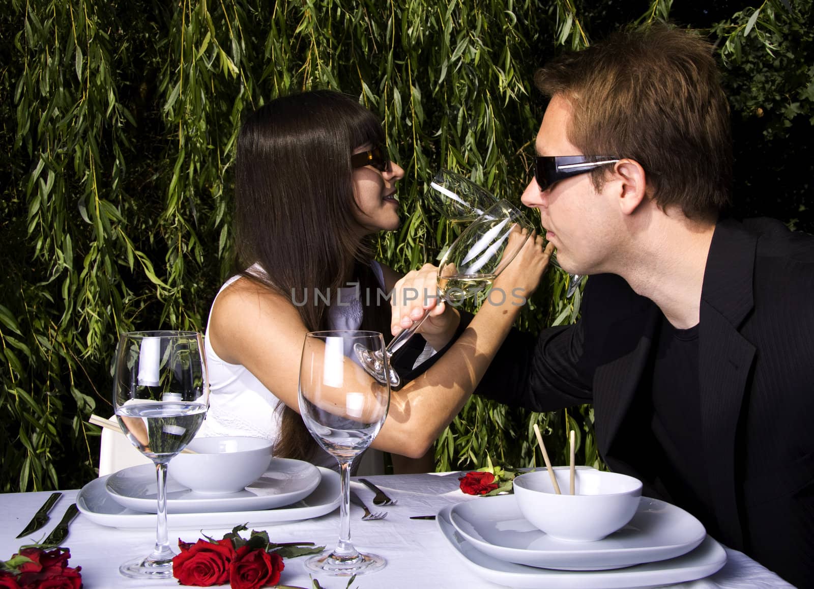 Couple having a romantic lunch in the garden enjoying wine