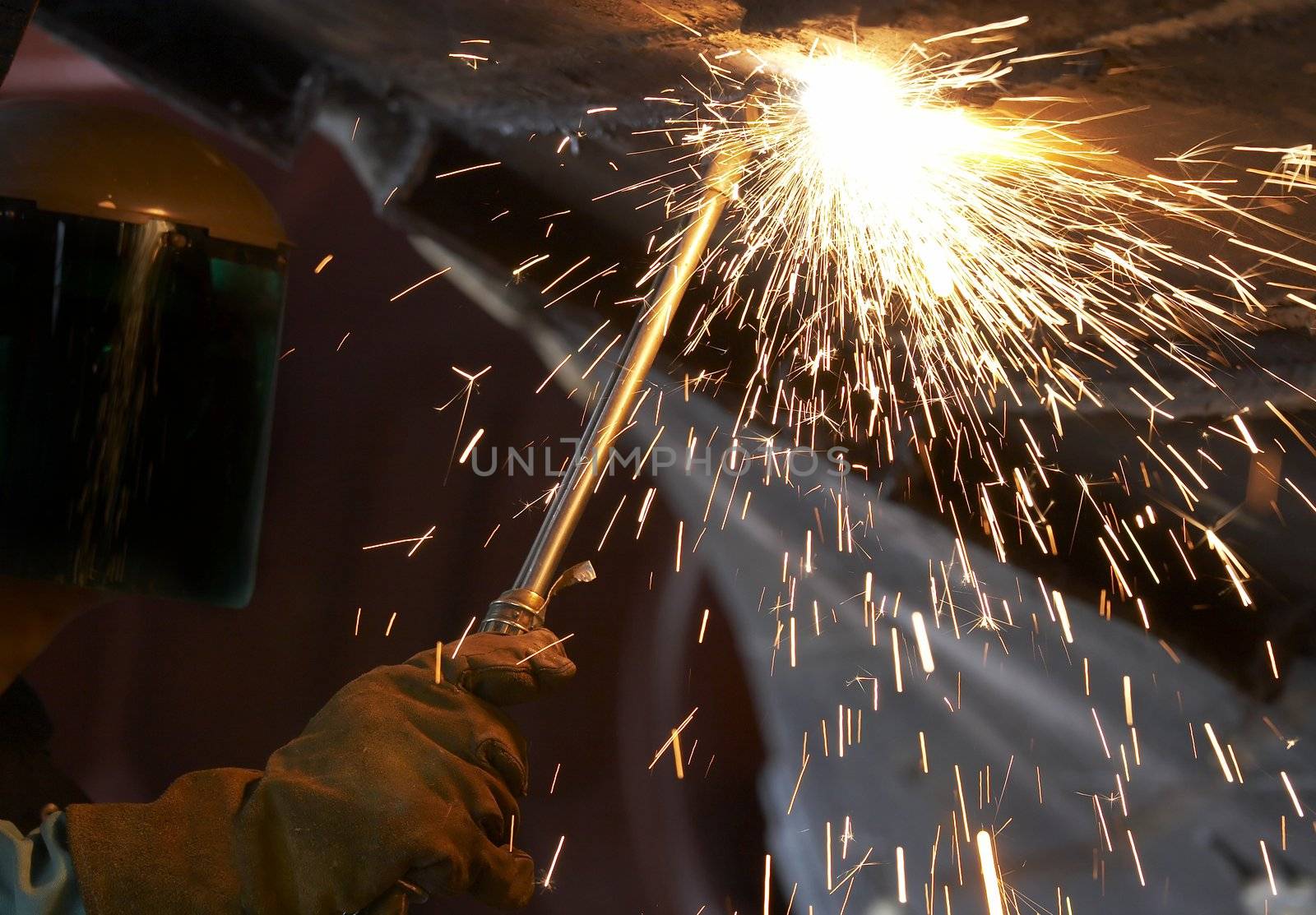 a steel worker burning metal with a torch