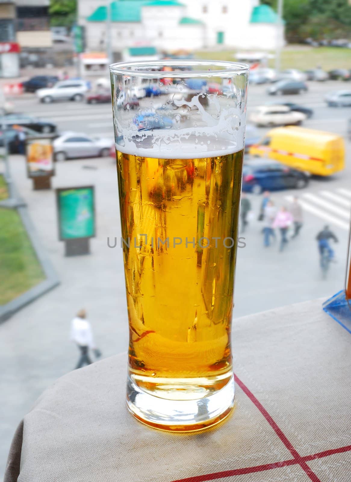 glass with beer on an a table and street background