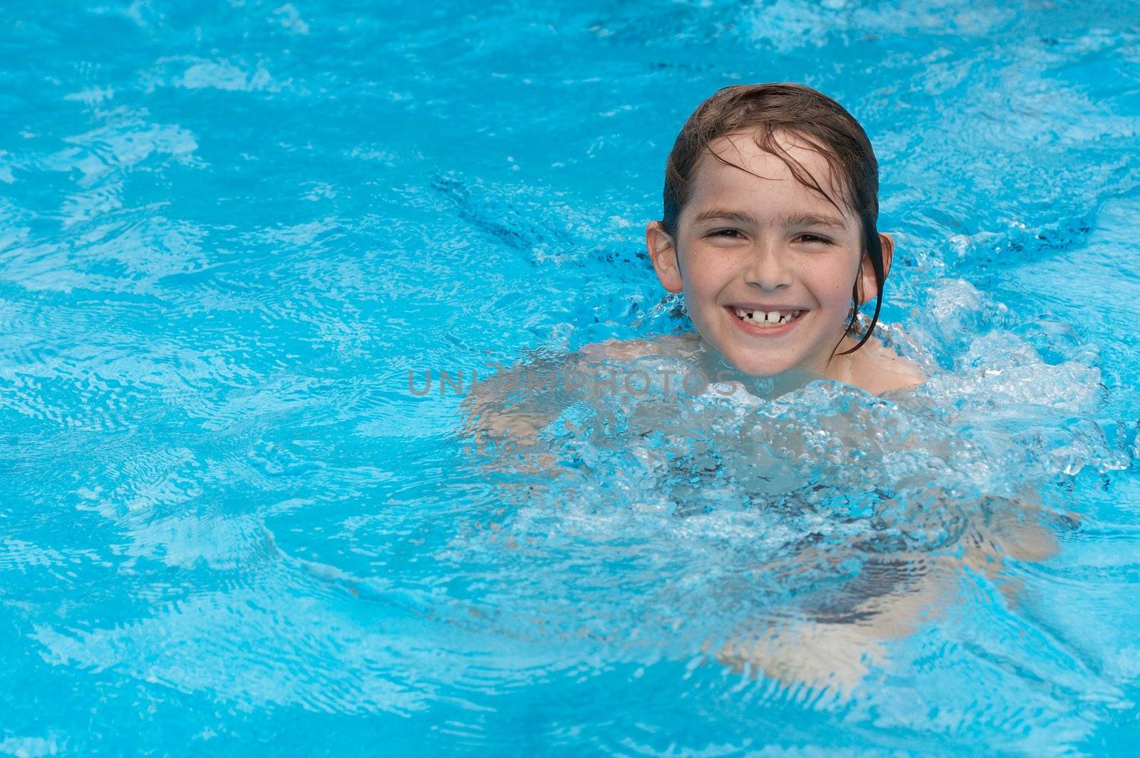 a boy smiling in swimming pool