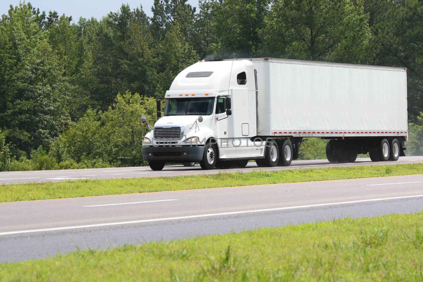 big white truck driving on a road