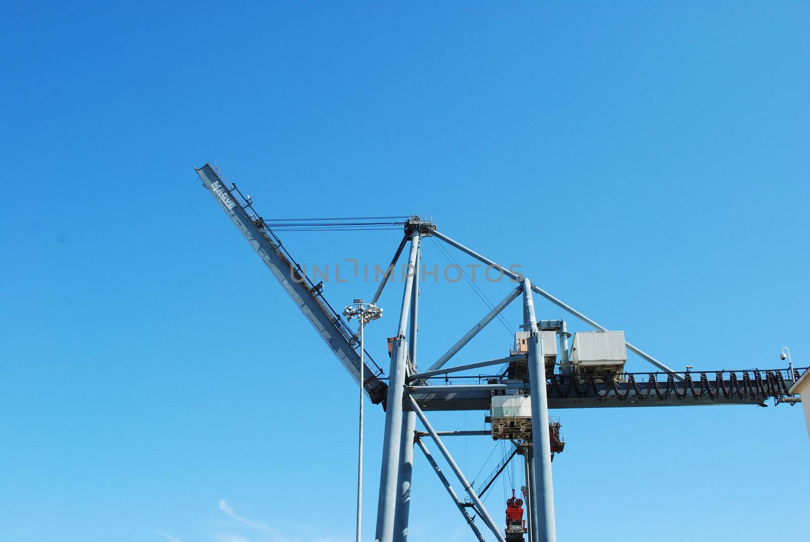 photo of heavy crane to load containers into ships against blue sky