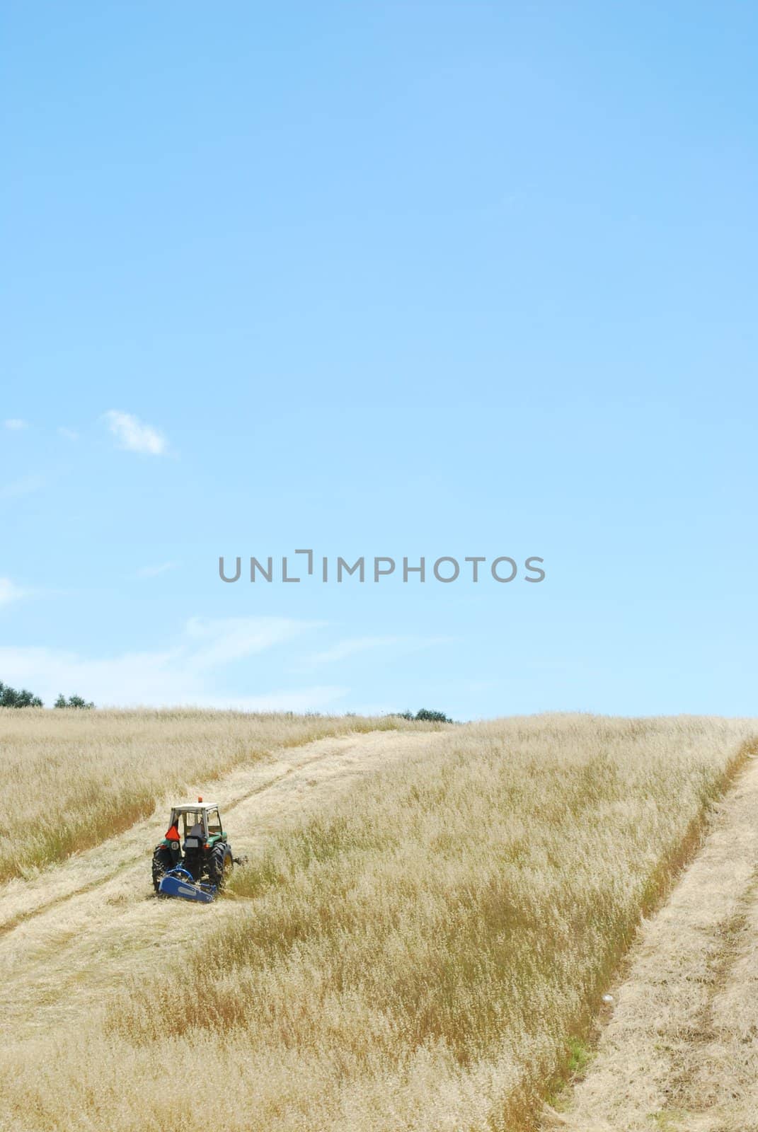 photo of a tractor harvesting on a wheat field