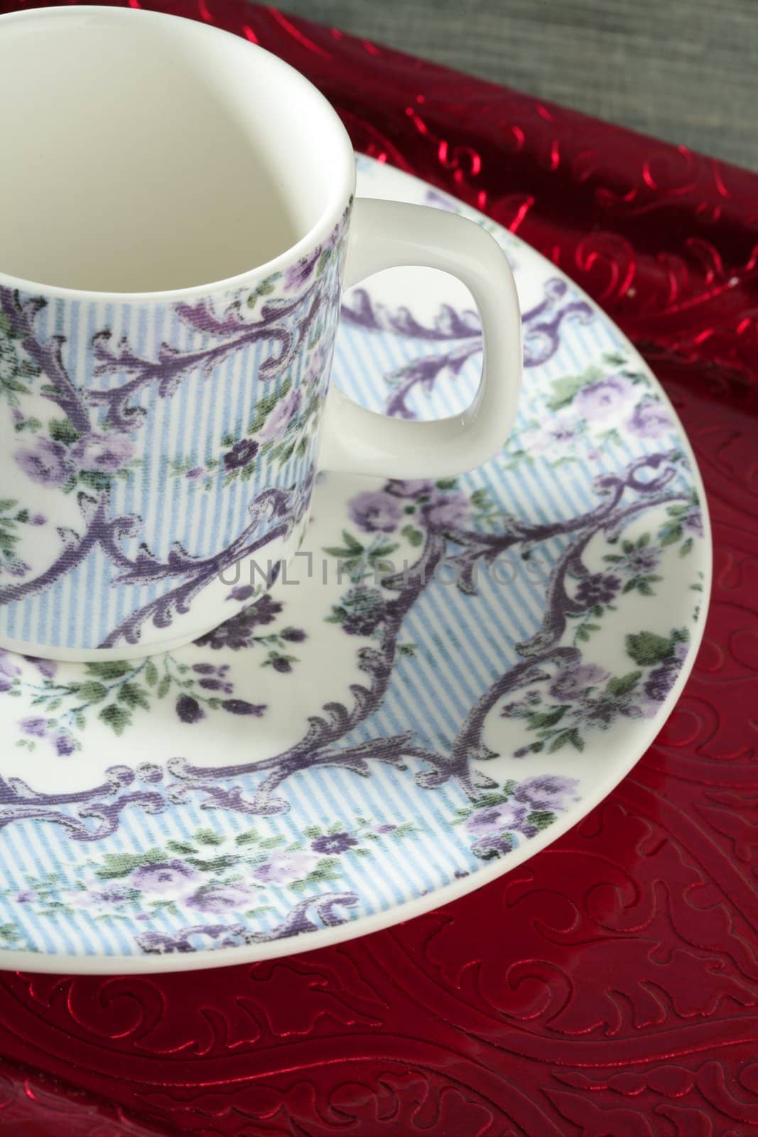 England old style tea cup and dish over red tray and blue wallpaper