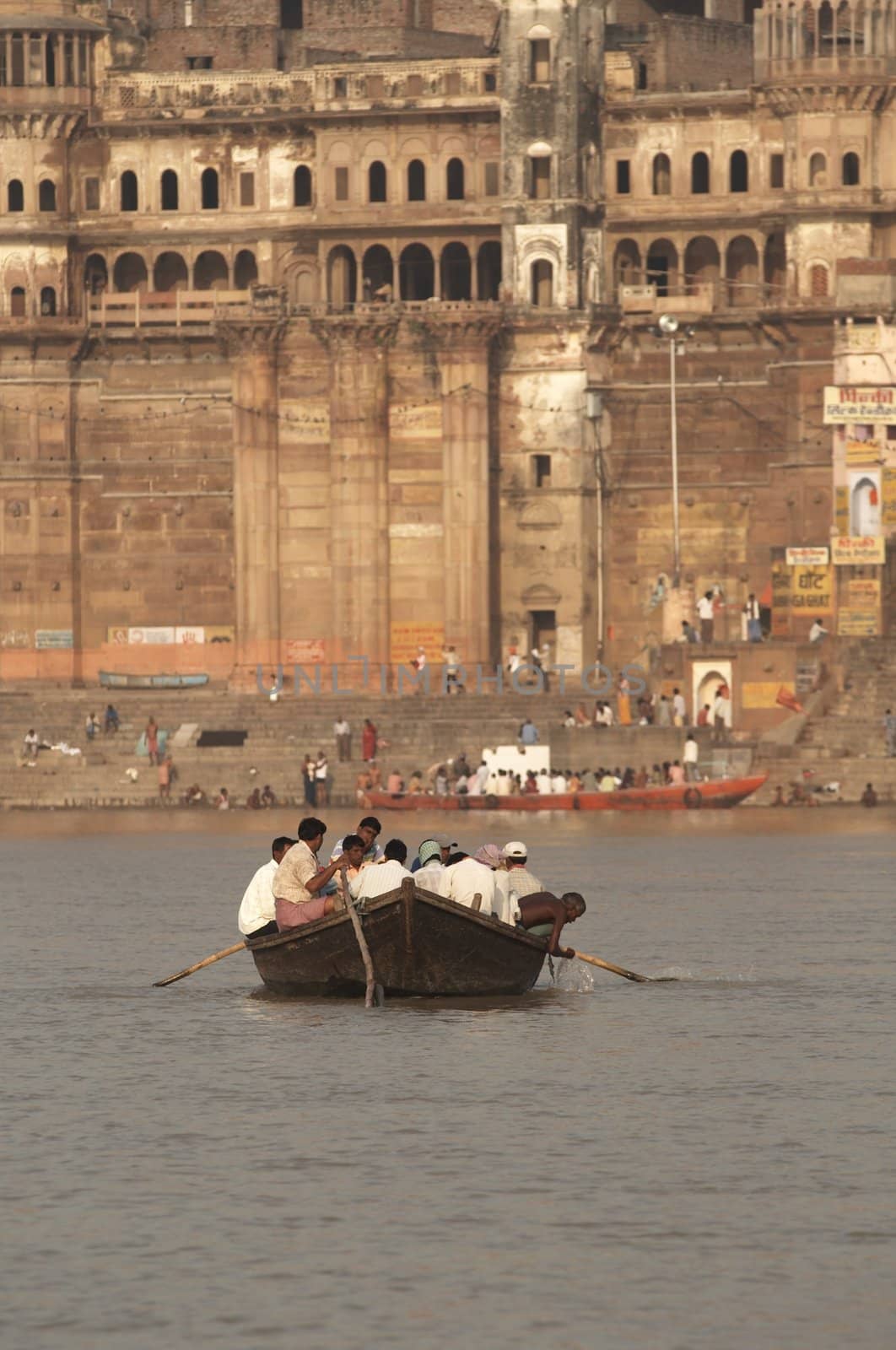 Boat full of people being rowed across the Ganges River at Varanasi, India