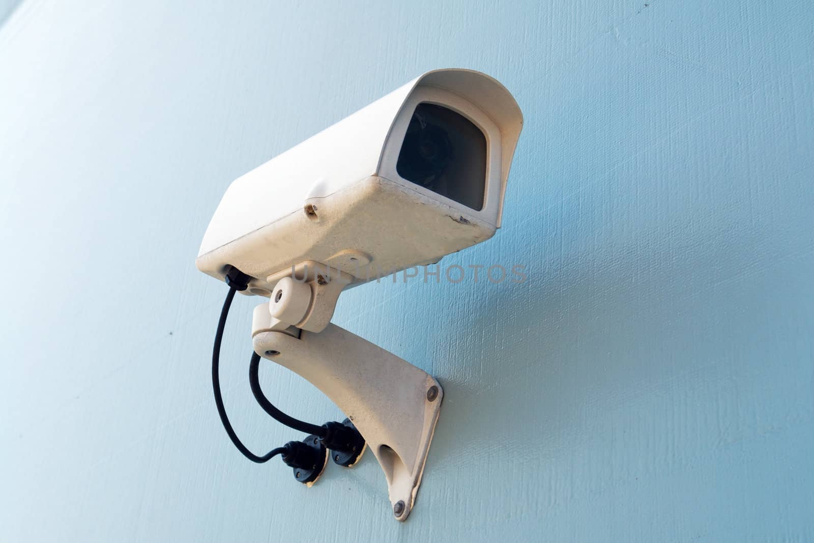 Security surveillance camera on a white wall Big Brother