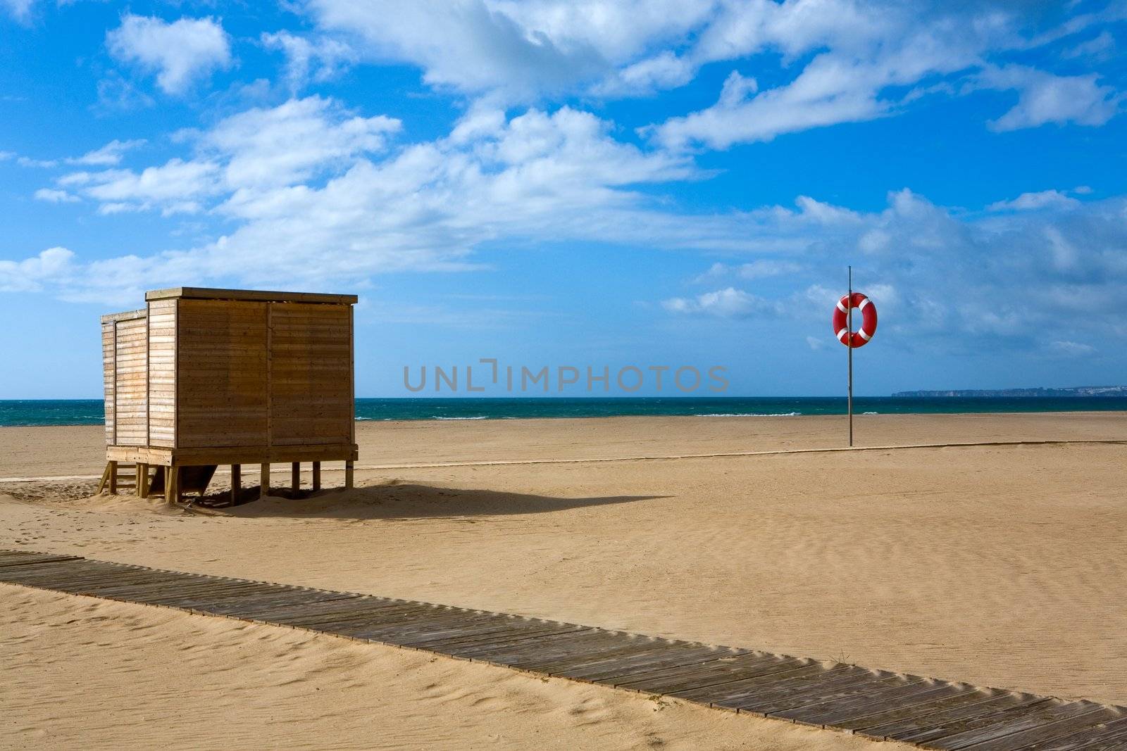 Deserted sandy beach under the dark blue sky with clouds
