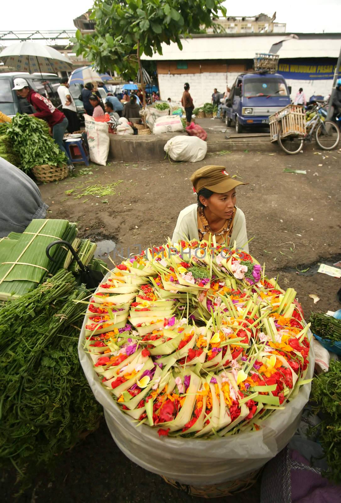 The young Indonesian girl sells baskets for sacrifice. Bali. Indonesia
