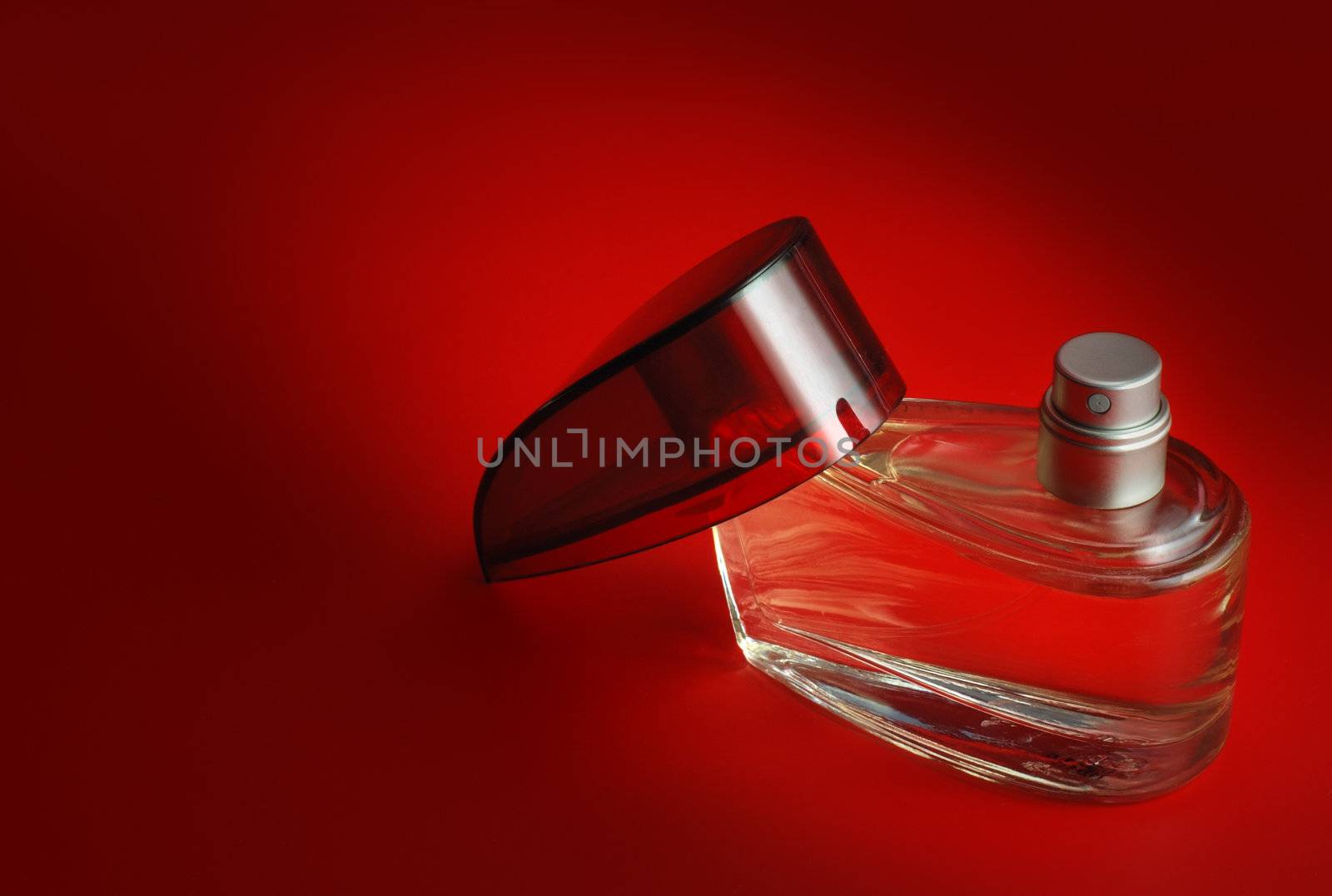 perfume. A bottle perfume on a red background with effective illumination