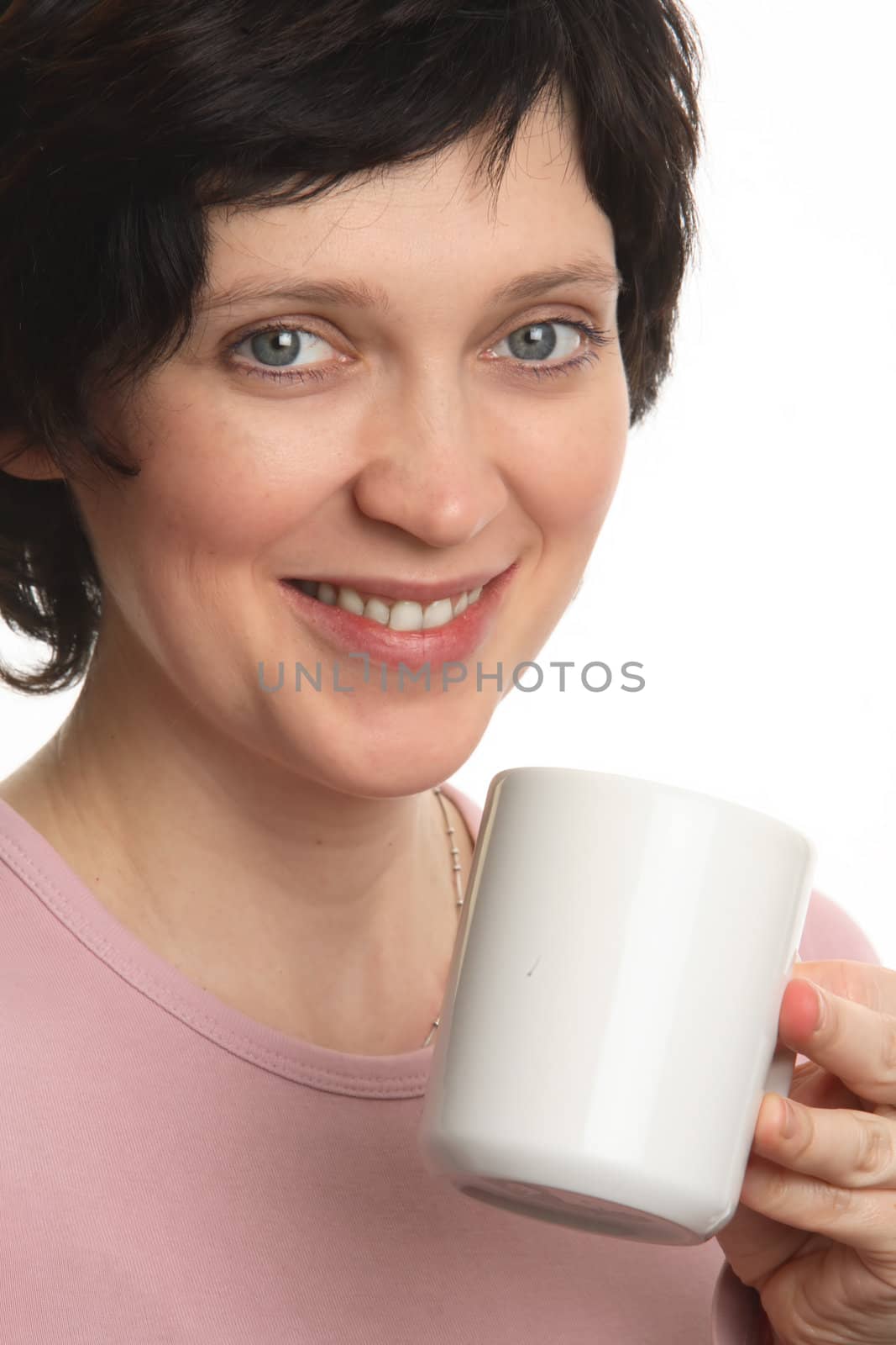 The girl holds a cup in hands and smiles