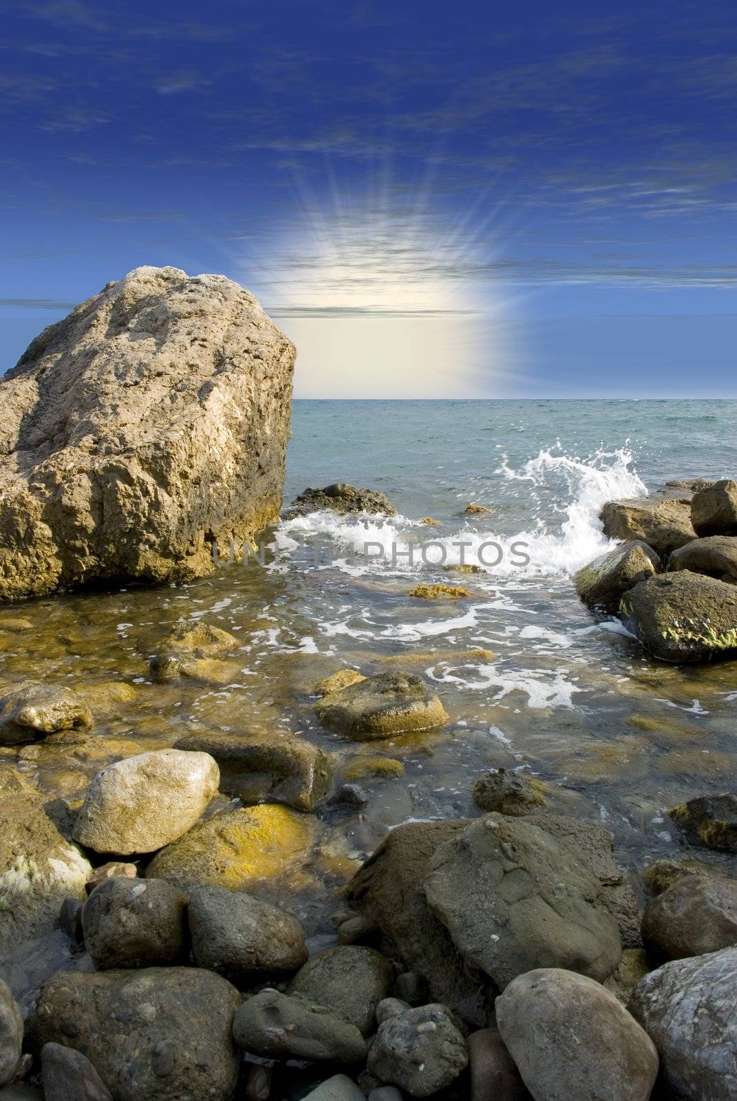 Sunrise at sea coast with picturesque stones in the foreground