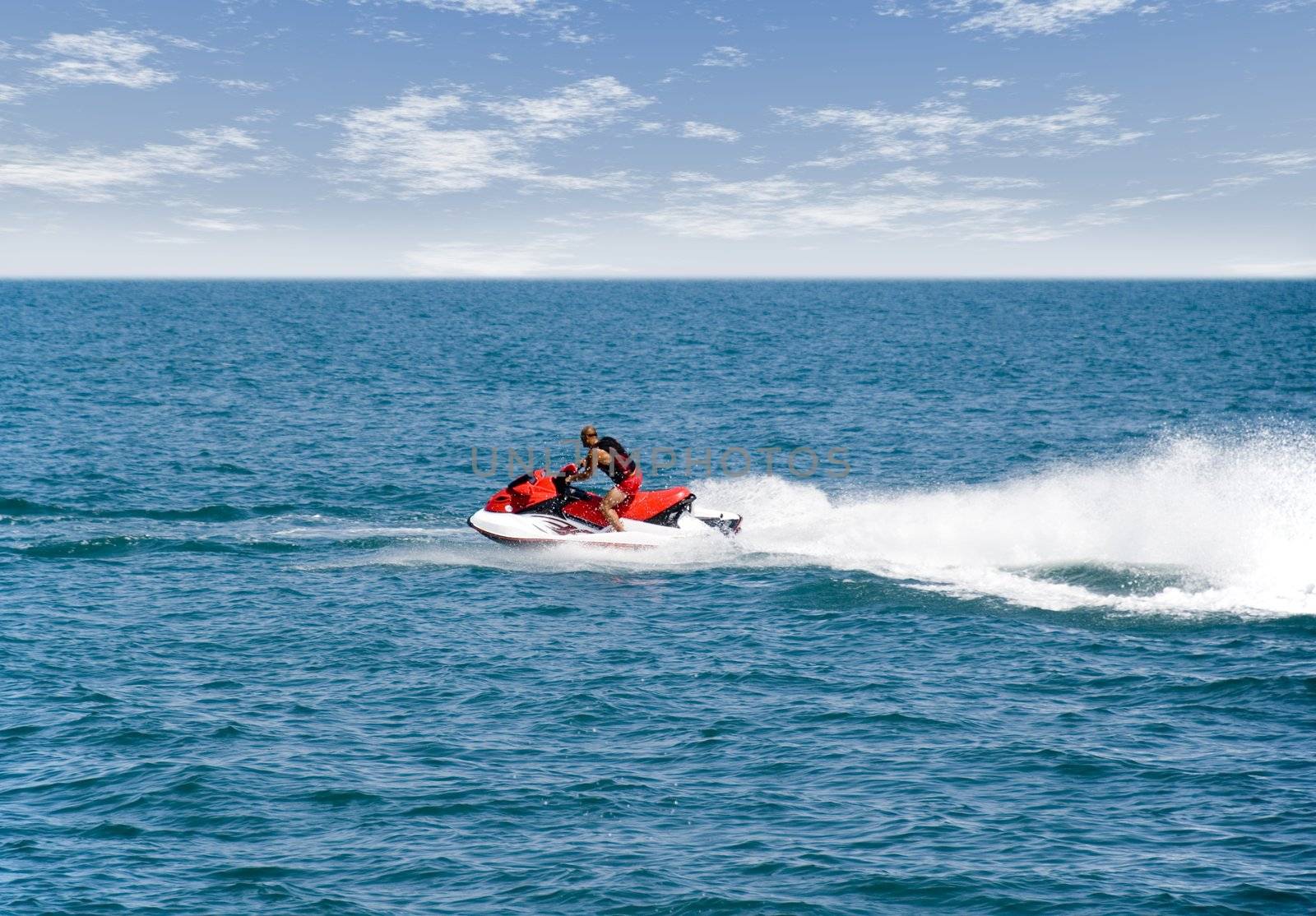 The hairless man on a water motorcycle. Greater speed and effective sparks of water