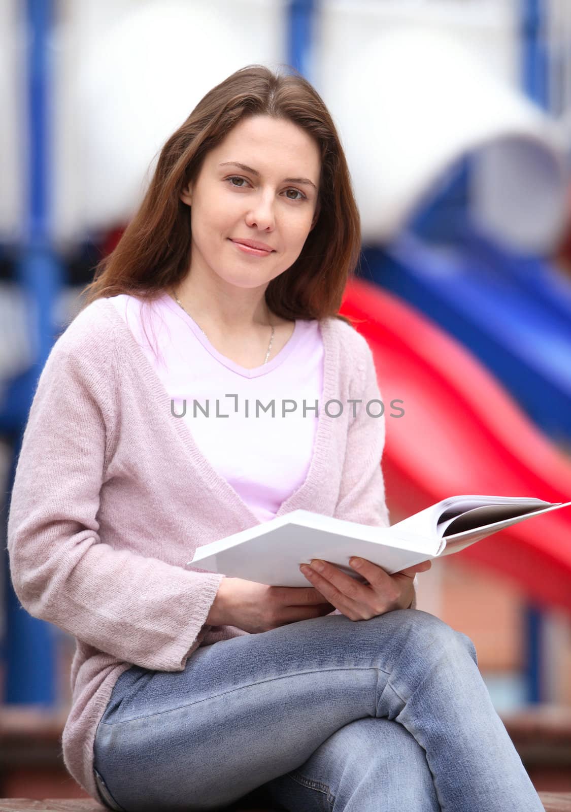 The girl sits on a bench with the book