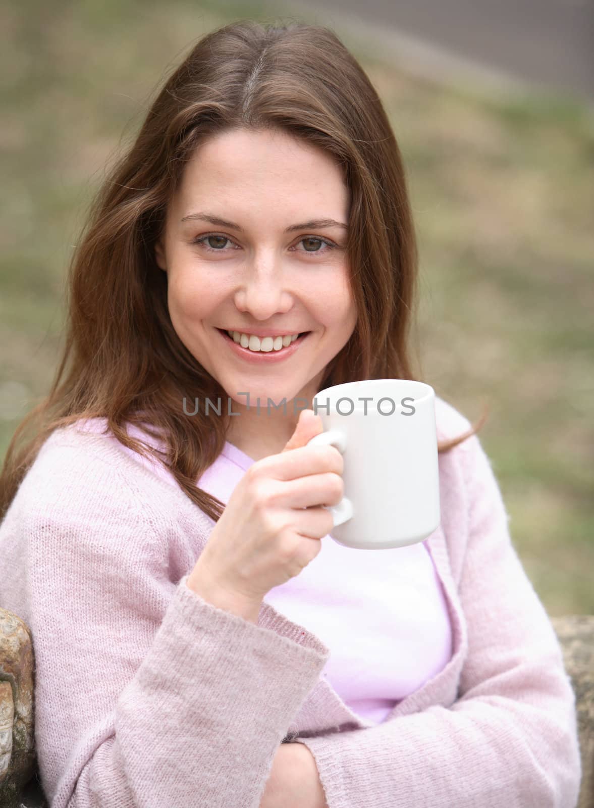 The girl holds a cup in hands and smiles